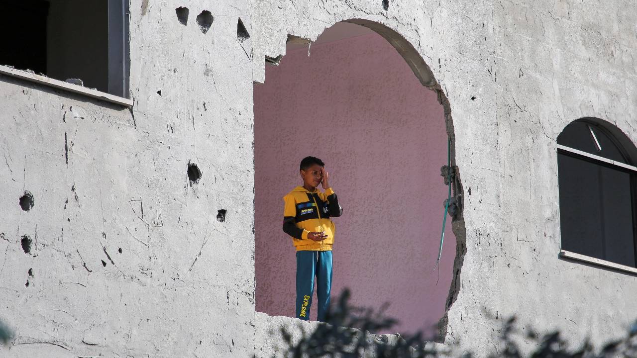 A child stands inside a building, damaged in an Israeli strike in Rafah. /Hatem Khaled/Reuters