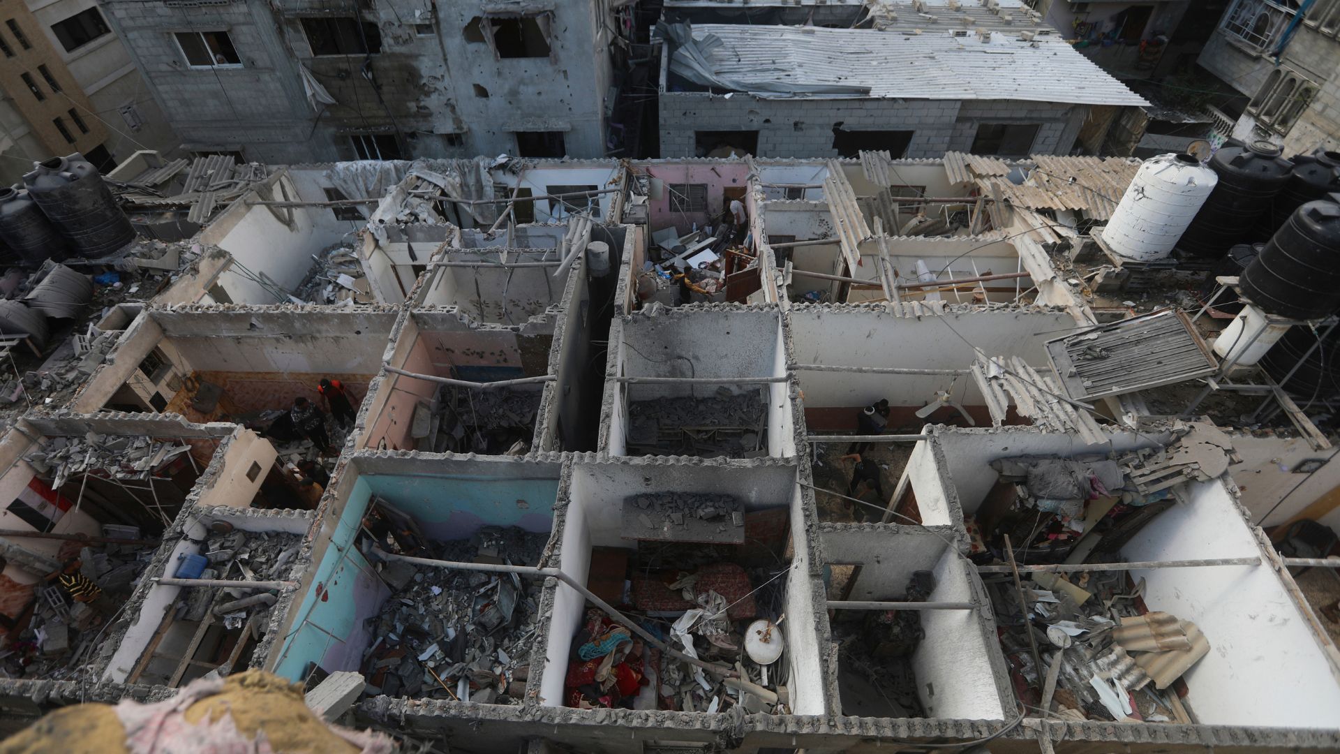 Palestinians look at the destruction after an Israeli strike on residential building in Rafah, Gaza Strip. /AP Photo/Ismael Abu Dayyah