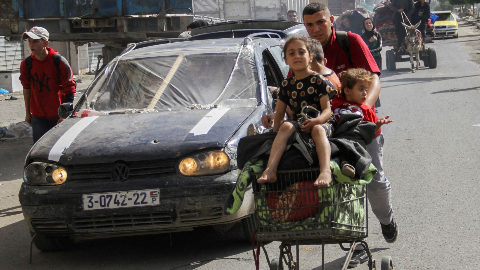 A displaced Palestinian man, who fled Jabalia after the Israeli military called on residents to evacuate, pushes children in a trolley towards Gaza City. /Mahmoud Issa/Reuters