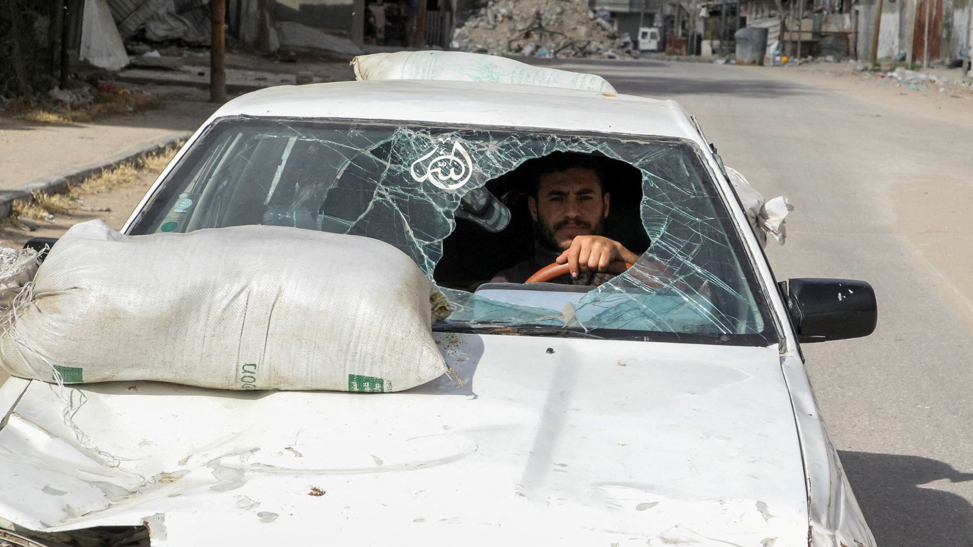 A displaced Palestinian man drives a car damaged during Israel's military offensive as he flees Rafah. /Hatem Khaled/Reuters
