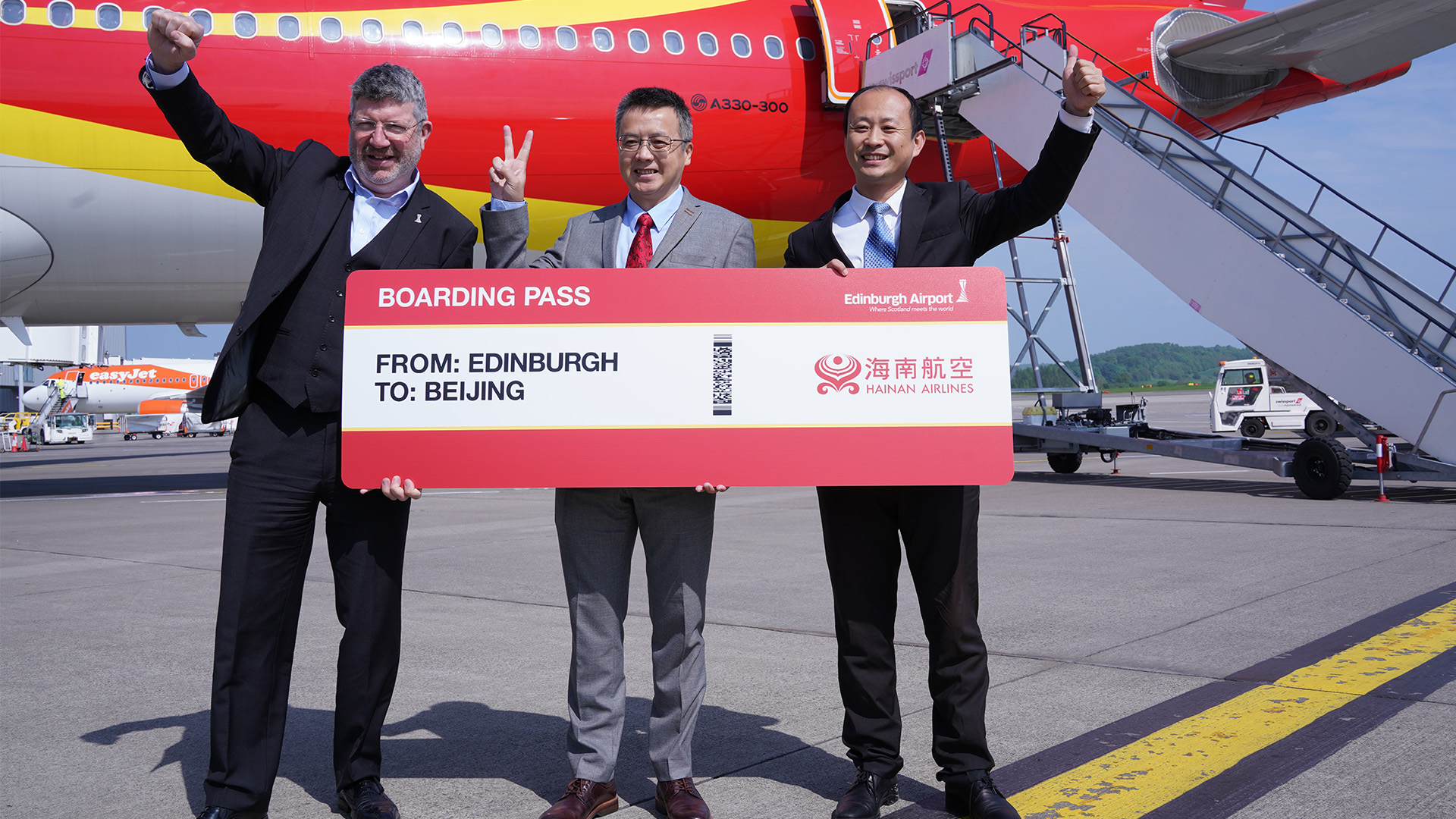 Chinese Consul General in Edinburgh Zhang Biao (M), Chief Executive of Edinburgh Airport Gordon Dewar (L), and director of Hainan Airlines in the UK & Ireland Han Zhi (R) attended an event celebrating the resuming of the direct flights from Beijing to Edinburgh at Edinburgh Airport. /CGTN