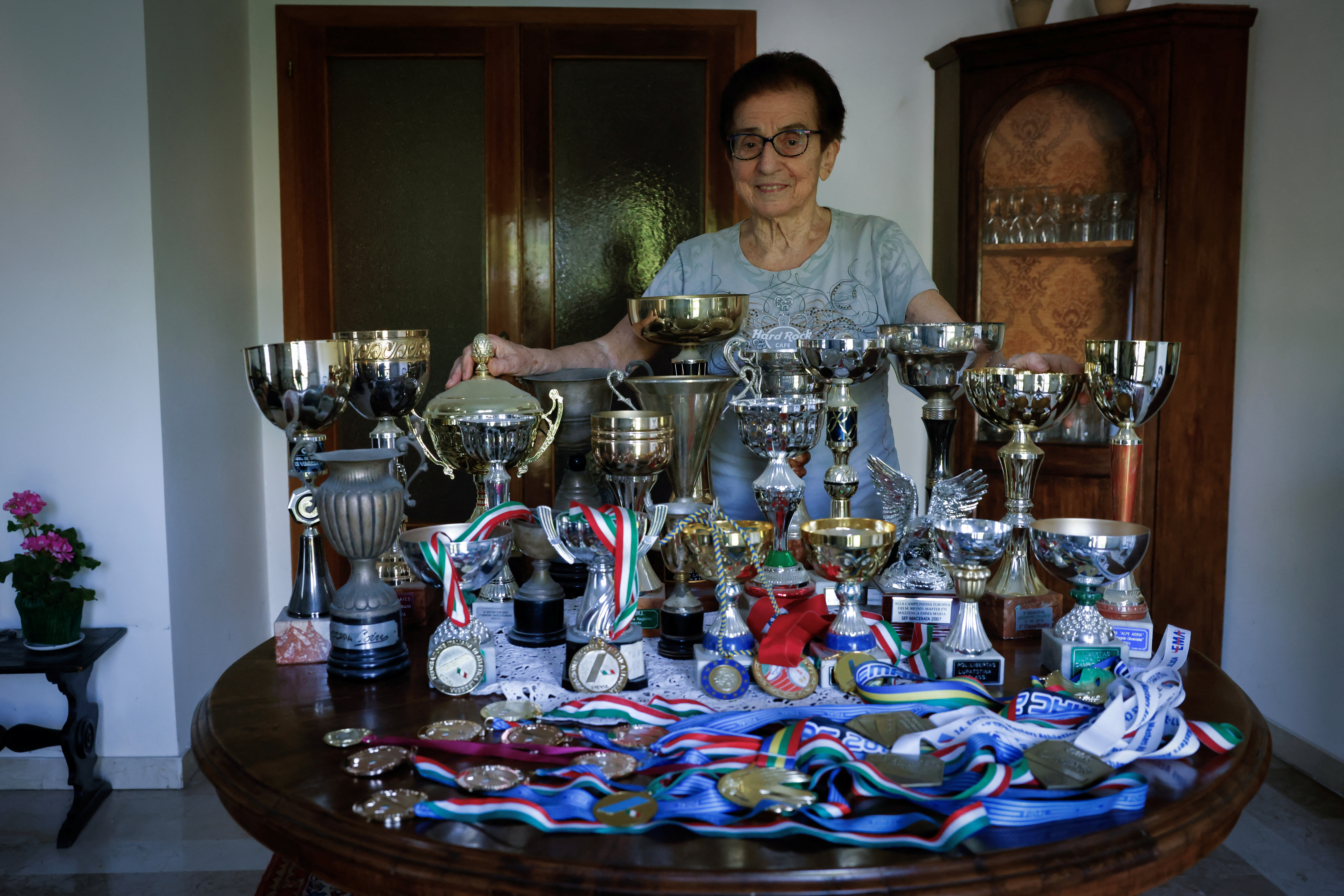 Italian master runner Emma Maria Mazzenga, 90, poses for a picture with some of her trophies, at home in Padua. /Remo Casilli/Reuters
