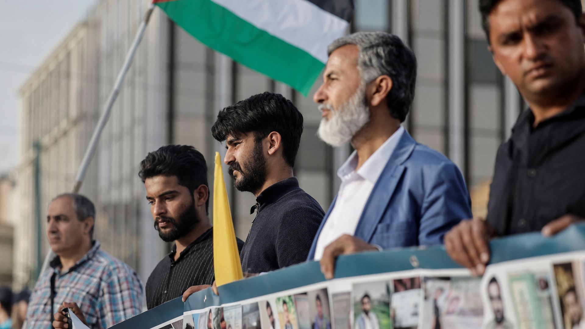 Survivors of the deadly migrant shipwreck, Zahid Akbar, 21, and Inzimam Maqbool, 22, from Pakistan, along with supporters participate in a protest calling for justice. /Louisa Gouliamaki/Reuters