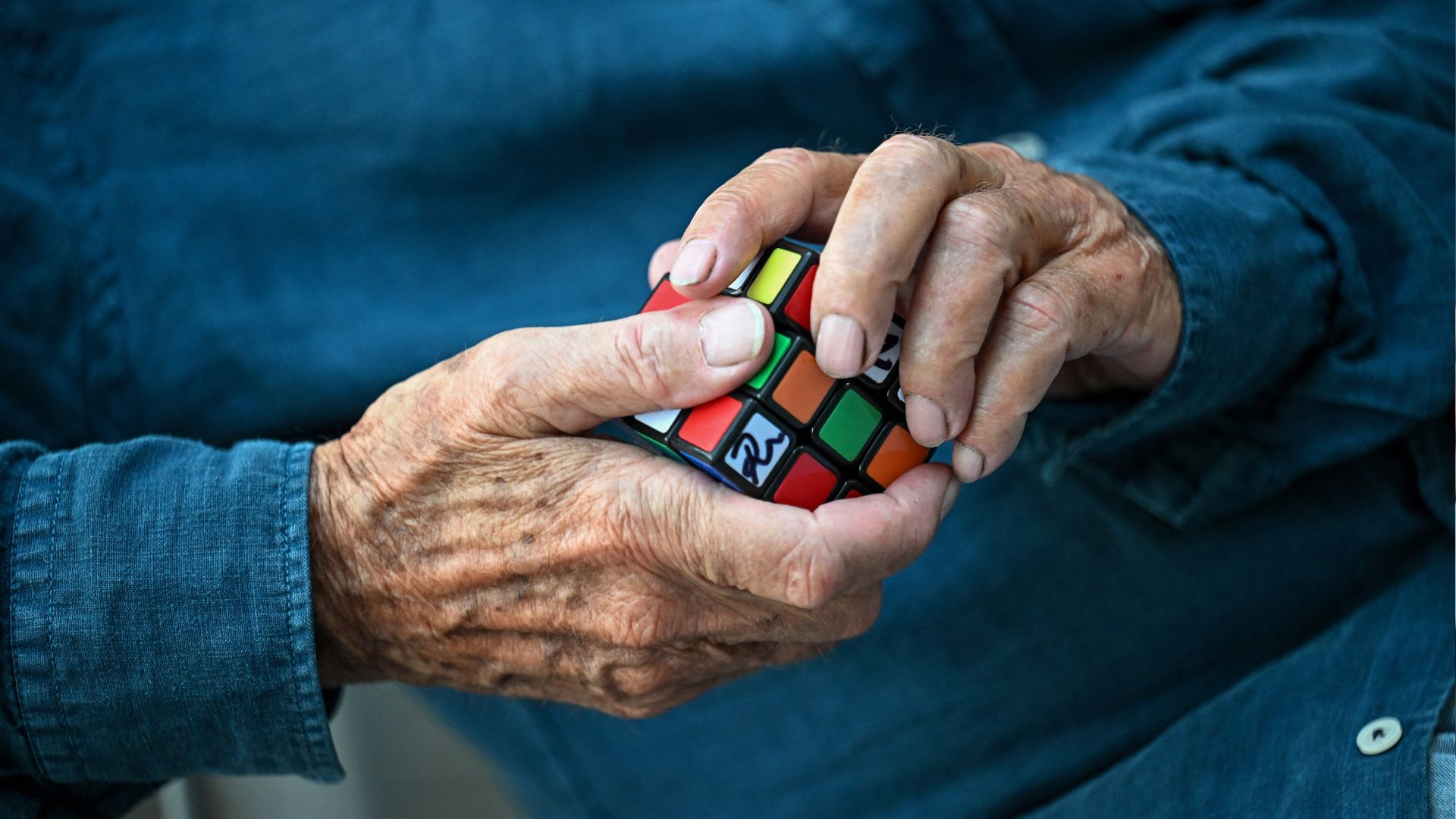 Erno Rubik holds a Rubik's Cube 3D puzzle in his hands. /Attila Kisbenedek/AFP