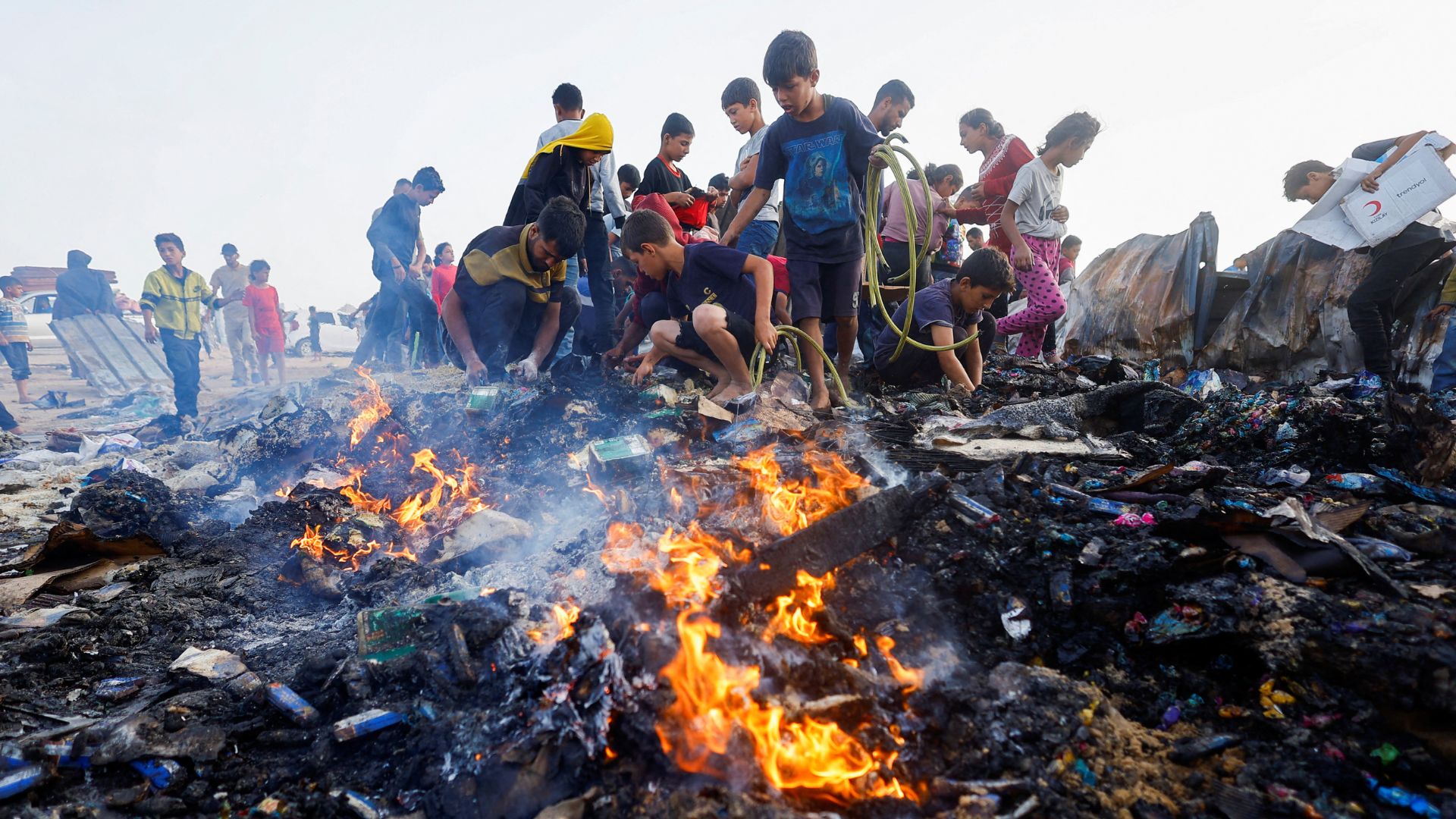 Palestinians search for food among burnt debris in the aftermath of the  Israeli air strikes. /Mohammed Salem/Reuters