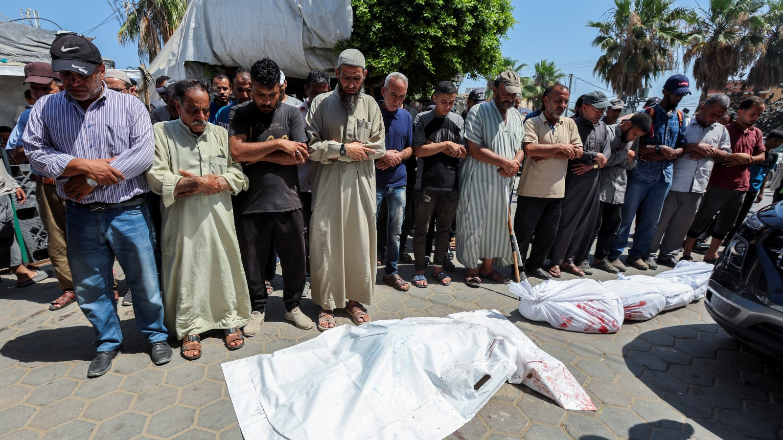 Mourners pray next to the bodies of Palestinians killed in Israeli strikes during their funeral at Al-Aqsa hospital in Deir Al-Balah in the central Gaza Strip. /Ramadan Abed/Reuters