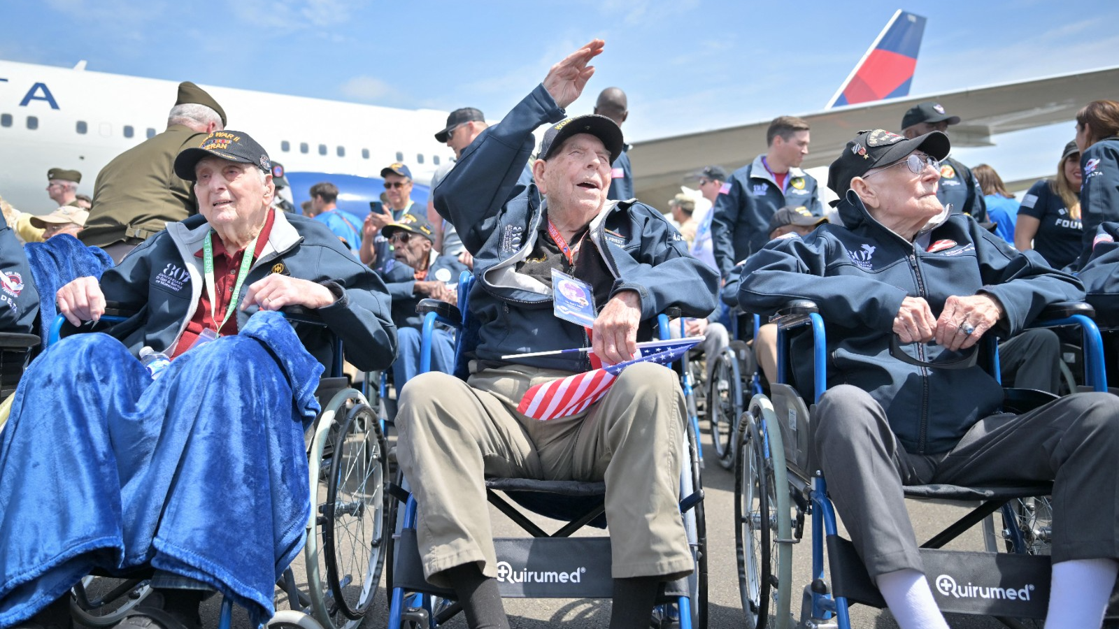 Veterans on wheelchairs wave as they arrive to mark the 80th anniversary of the World War II Allied landings in Normandy. /Lou Benoist/AFP