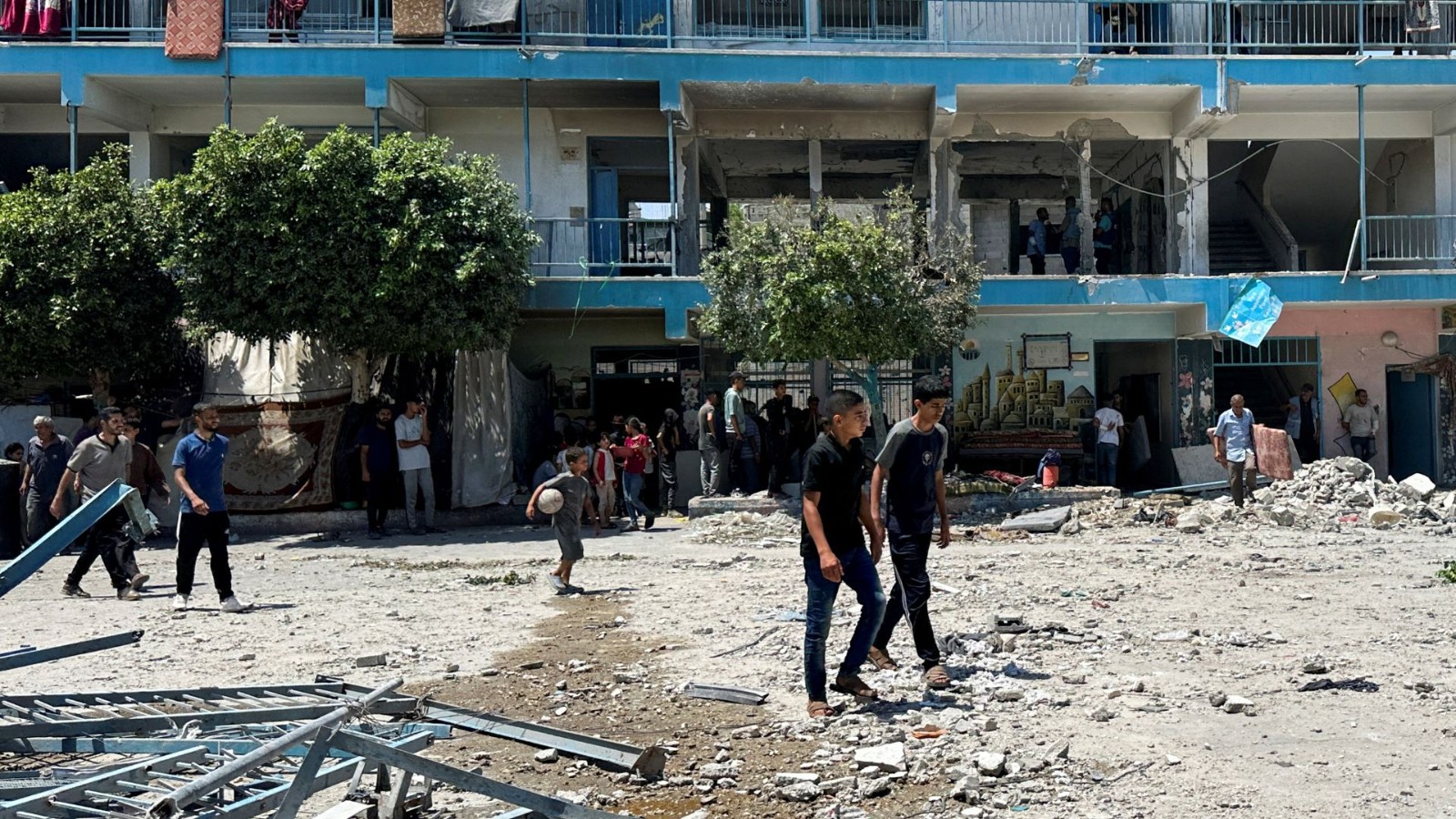 Palestinians inspect the site of an Israeli strike on a UNRWA school sheltering displaced people in Nuseirat refugee camp. /Doaa Rouqa/Reuters