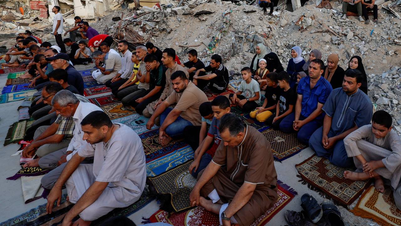 Palestinians hold Eid al-Adha prayers by the ruins of the Al-Rahma mosque destroyed by Israeli air strikes on Saturday. /Mohammed Salem/Reuters