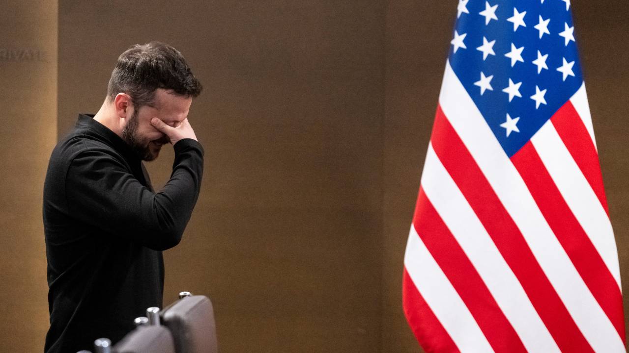 Ukrainian President Volodymyr Zelenskyi covers his eyes between two bilateral meetings during the summit on Ukraine. /Alessandro della Valle/Pool/Reuters