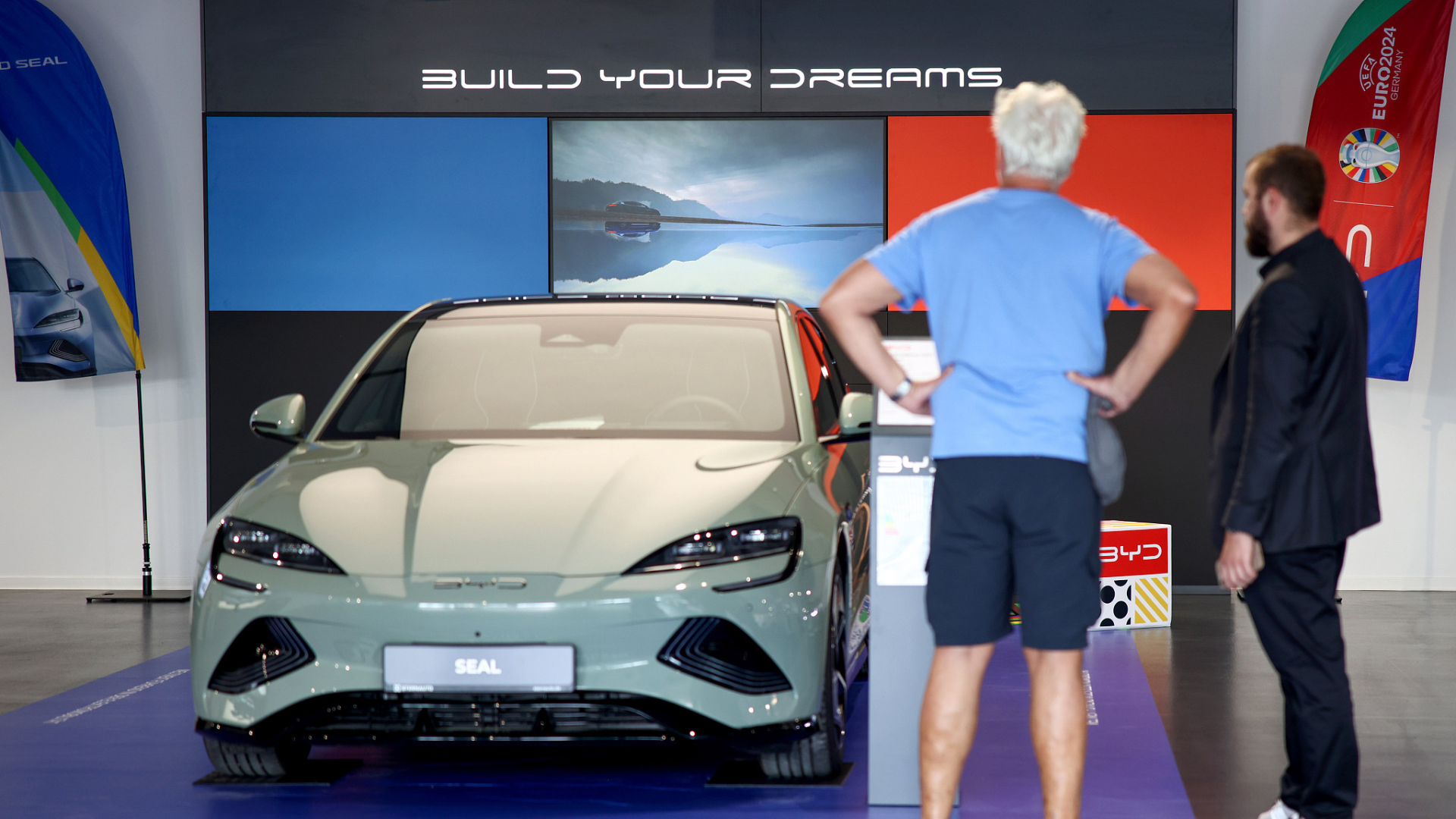 Customers look at electric vehicles at a BYD Co. showroom, operated by Sternauto, in Berlin. /CFP