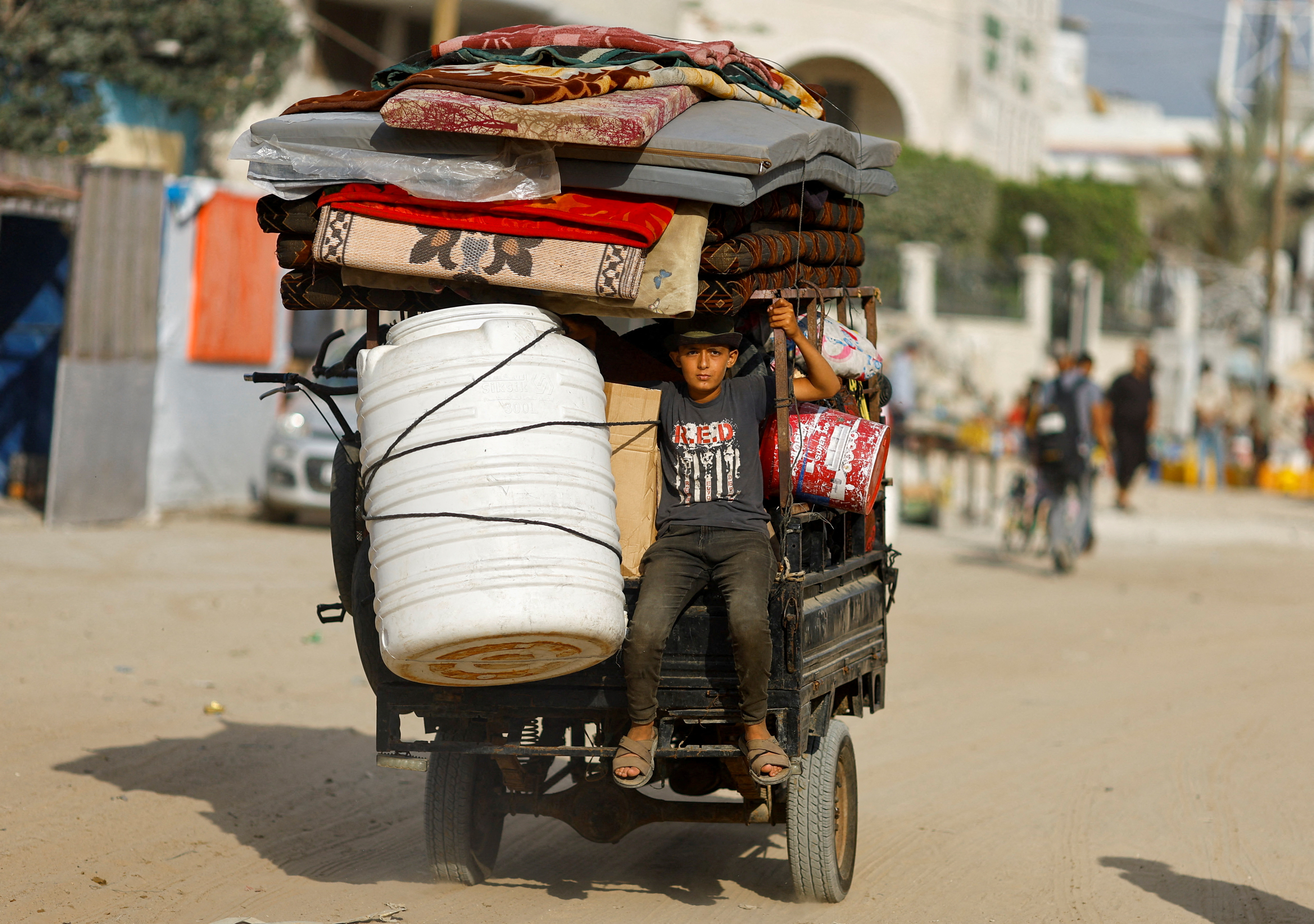 A Palestinian boy, who fled the eastern part of Khan Younis after they were ordered by Israeli army to evacuate their neighborhoods, rides on a vehicle loaded with belongings. /Mohammed Salem/Reuters