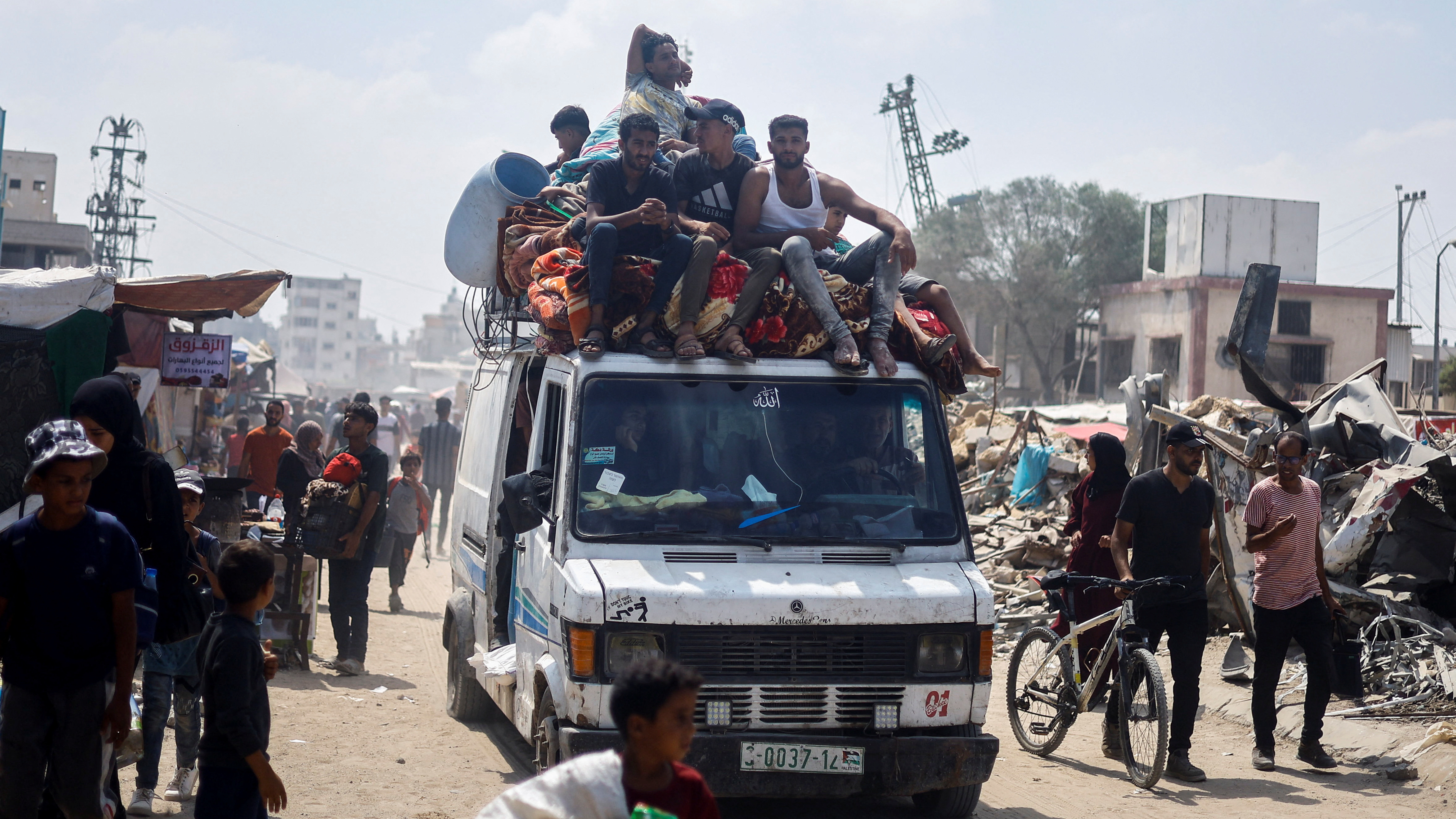 Palestinians, who fled the eastern part of Khan Younis after they were ordered by Israeli army to evacuate their neighborhoods, ride on a vehicle loaded with belongings. /Mohammed Salem/Reuters