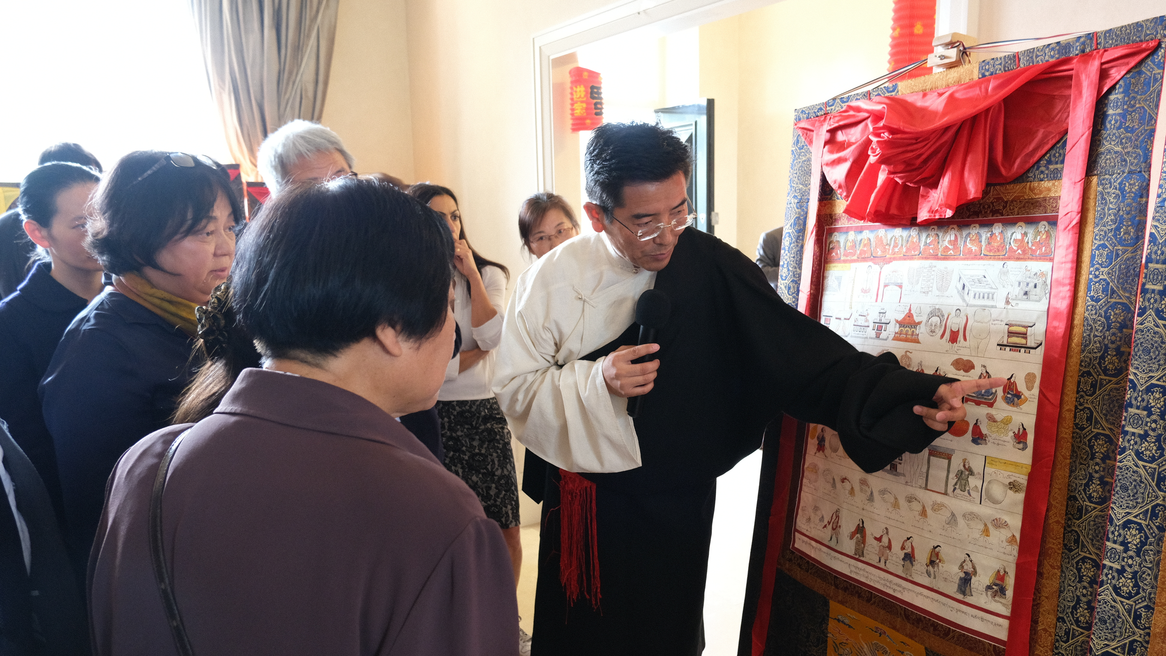 Tsering, Director of the Xizang Hospital of the Xizang Autonomous Region, led a tour of the pantings. /CGTN