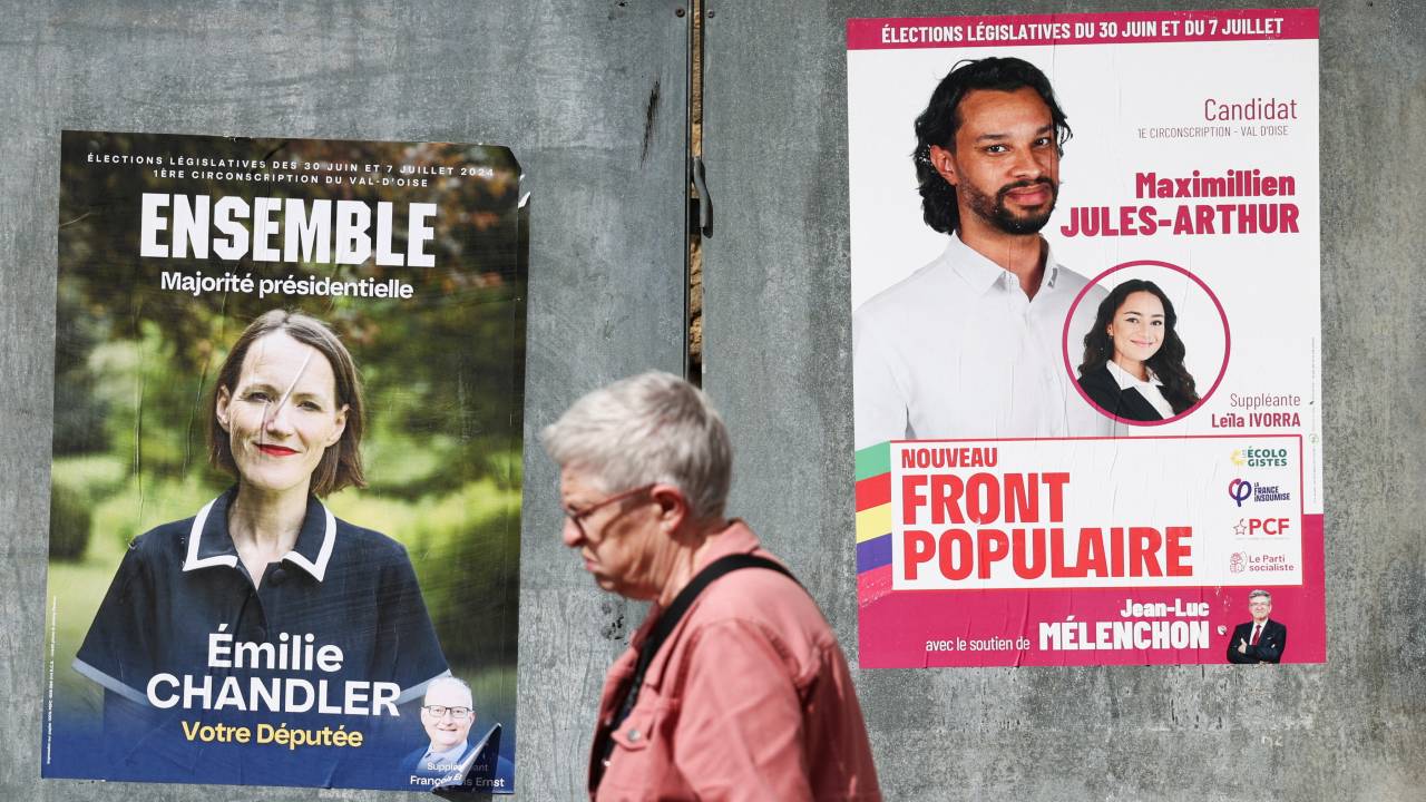 A person walks past election campaign posters prior to the second round of the early French parliamentary election. /Yara Nardi/Reuters