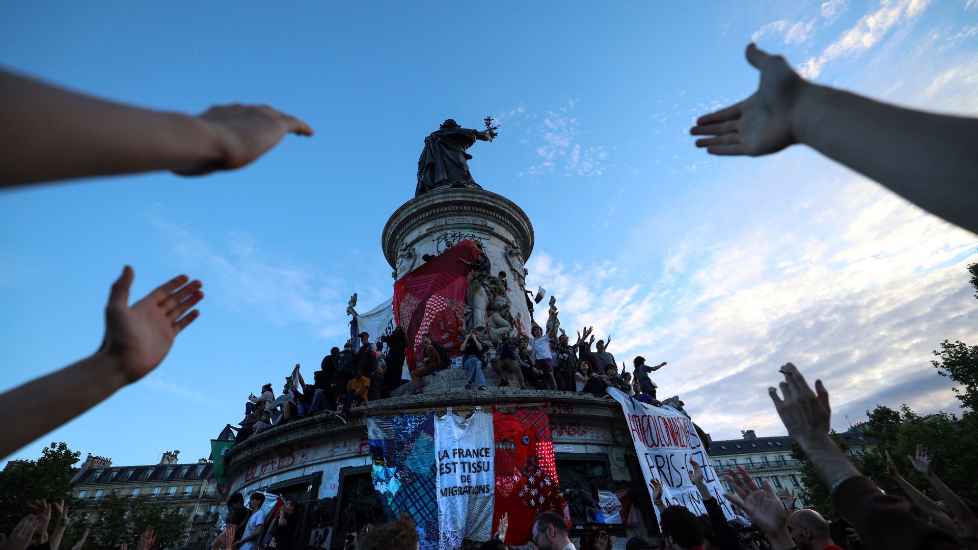 A giant banner reads 'France is the fabric of migration' at an election night rally in Paris. /Emmanuel Dunand/AFP