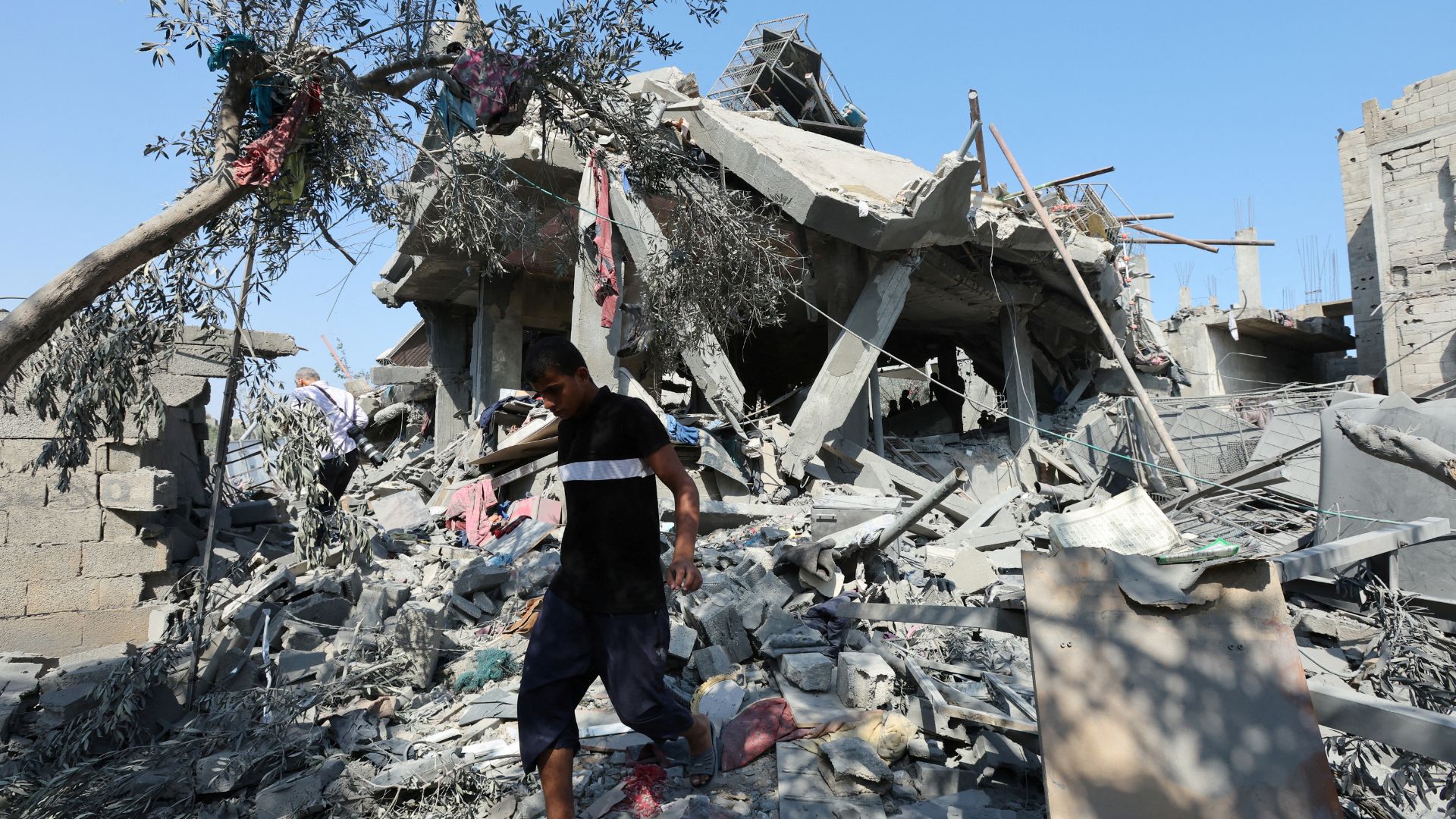 Palestinians inspect a house destroyed in an Israeli strike on the Nuseirat refugee camp. /Ramadan Abed/Reuters