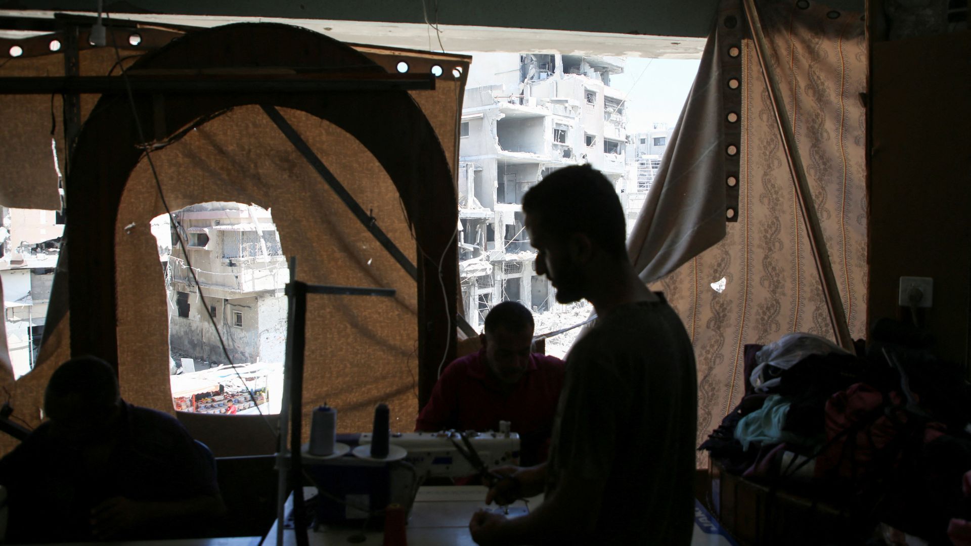 Palestinian tailors work in a newly reopened sewing factory in Khan Younis. /Hatem Khaled/Reuters