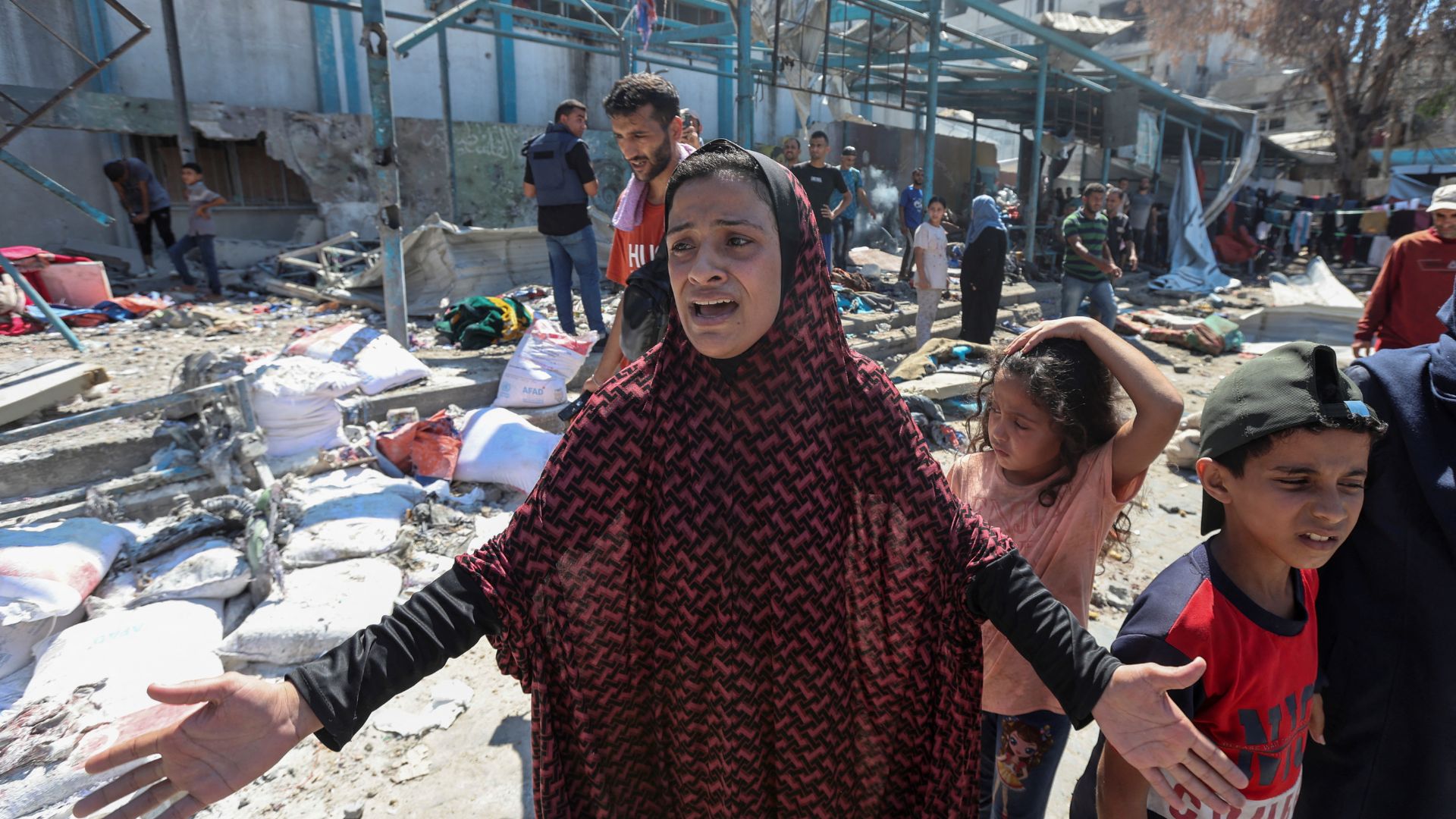 A displaced Palestinian woman reacts at a UN school used as a shelter, following an Israeli strike on Nuseirat. /Ramadan Abed/Reuters