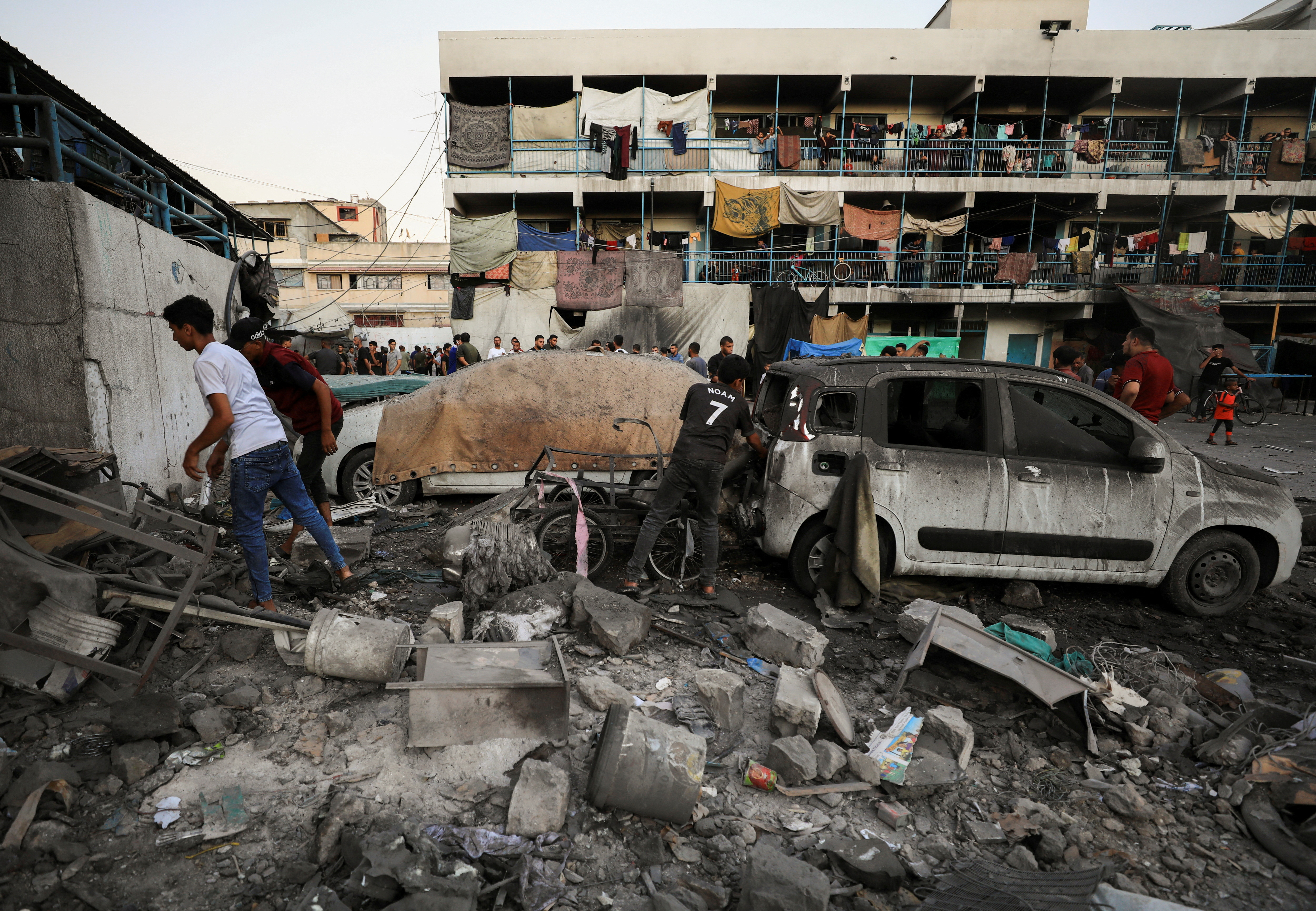 Palestinians remove debris at a UN-run school sheltering displaced people, following an Israeli strike in Gaza City. /Dawoud Abu Alkas/Reuters