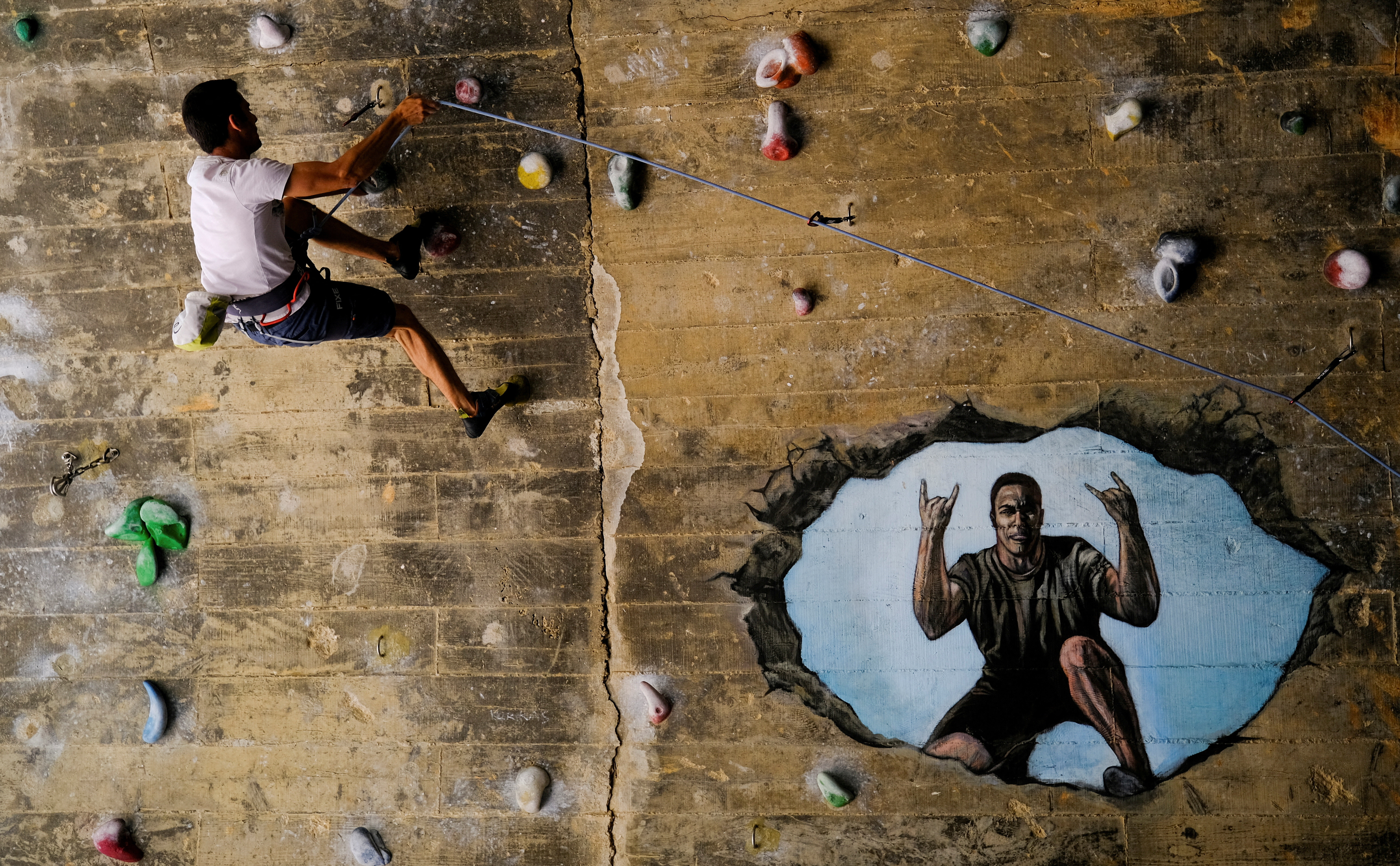 Jose Sanchez Aguilera, 30, climbs the Foixarda tunnel, a former road tunnel transformed into an urban, free-to-use climbing gym open at all times. /Nacho Doce/Reuters