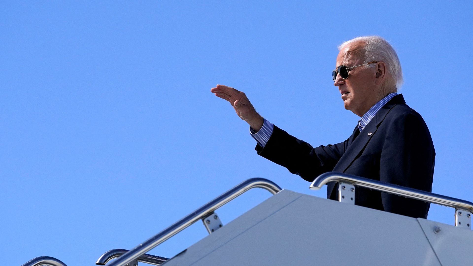 Joe Biden waves while boarding the presidential plane Air Force One, earlier this month. /Nathan Howard/Reuters