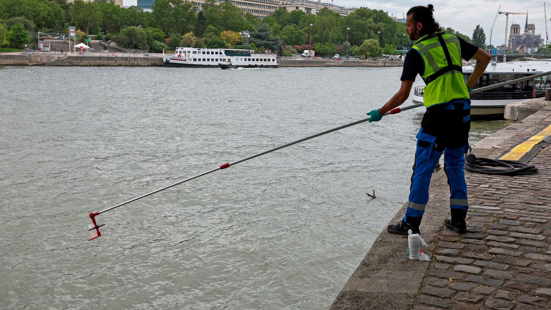 A municipal employee demonstrates the sampling of the water of the River Seine near Notre-Dame. /Gonzalo Fuentes/Reuters