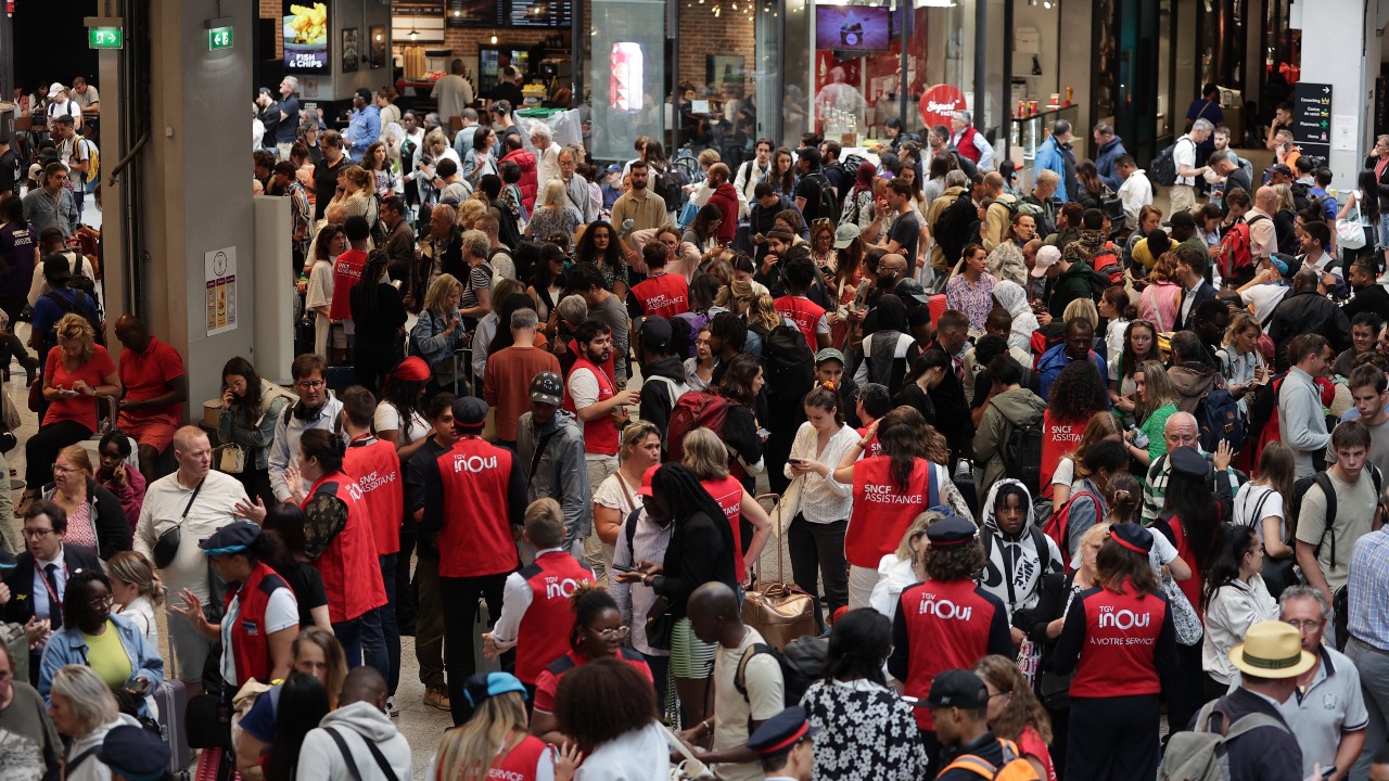 Employees of France's SNCF railway company speak to passengers waiting for their trains' departure at the Gare Montparnasse train station in Paris. /Thibaud Moritz/AFP