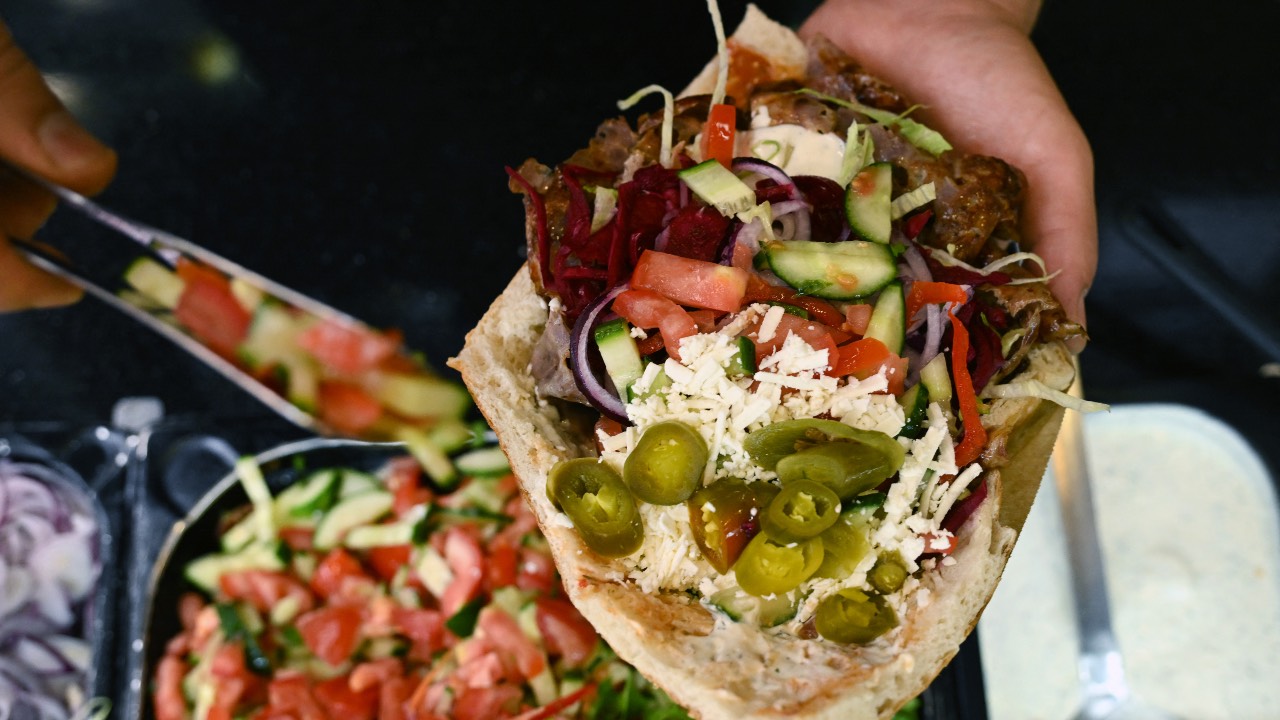 An employee prepares a doner with meat from a kebab skewer in a doner restaurant. /Ina Fassbender/AFP