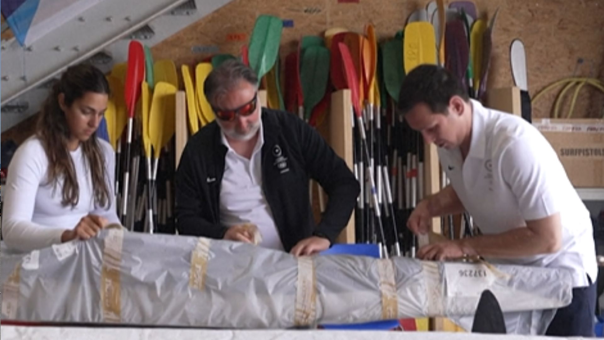 Iranian-born kayaker Saman Soltani (left) opens her canoe with her team. /AFP