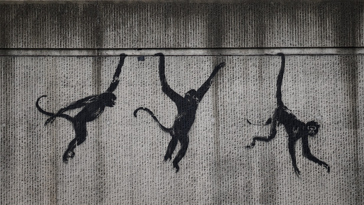 An artwork by street artist Banksy, the third to be released in three days, depicting three monkeys, is pictured painted on the side of a railway bridge in east London. The artist confirmed the work to be theirs after posting an image of it on Instagram. /Henry Nicholls/AFP