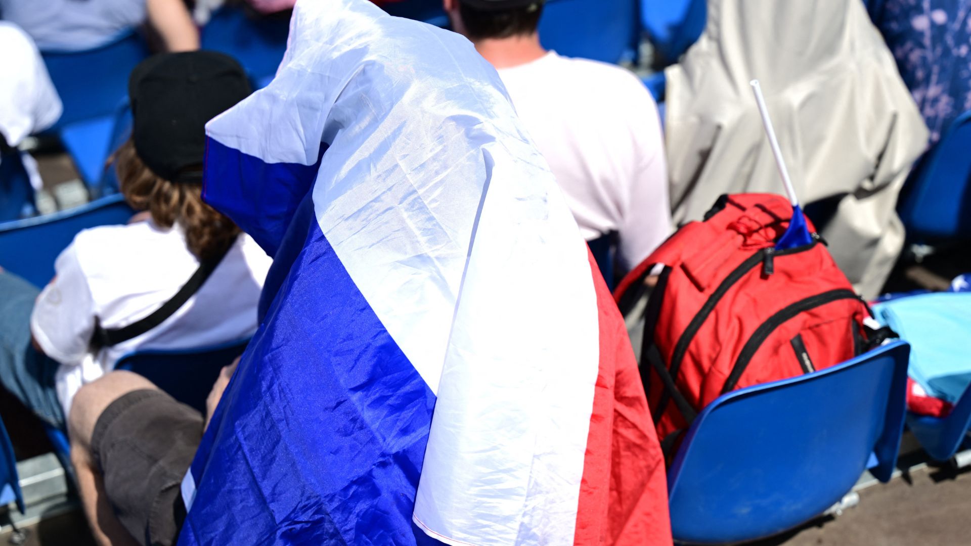 A spectator wears a France flag over their head to keep cool during the heats. /Angelika Warmuth/Reuters