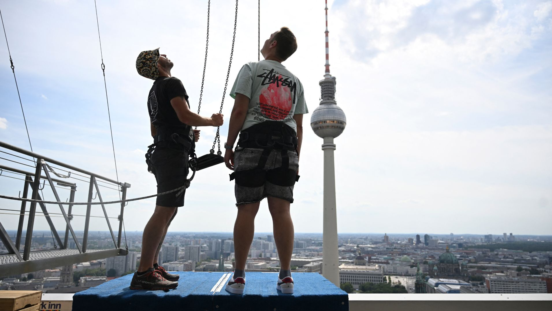 Pascal Vent (right) gets ready to sways 120m above the rooftops of Berlin. /Ralf Hirschberger/AFP