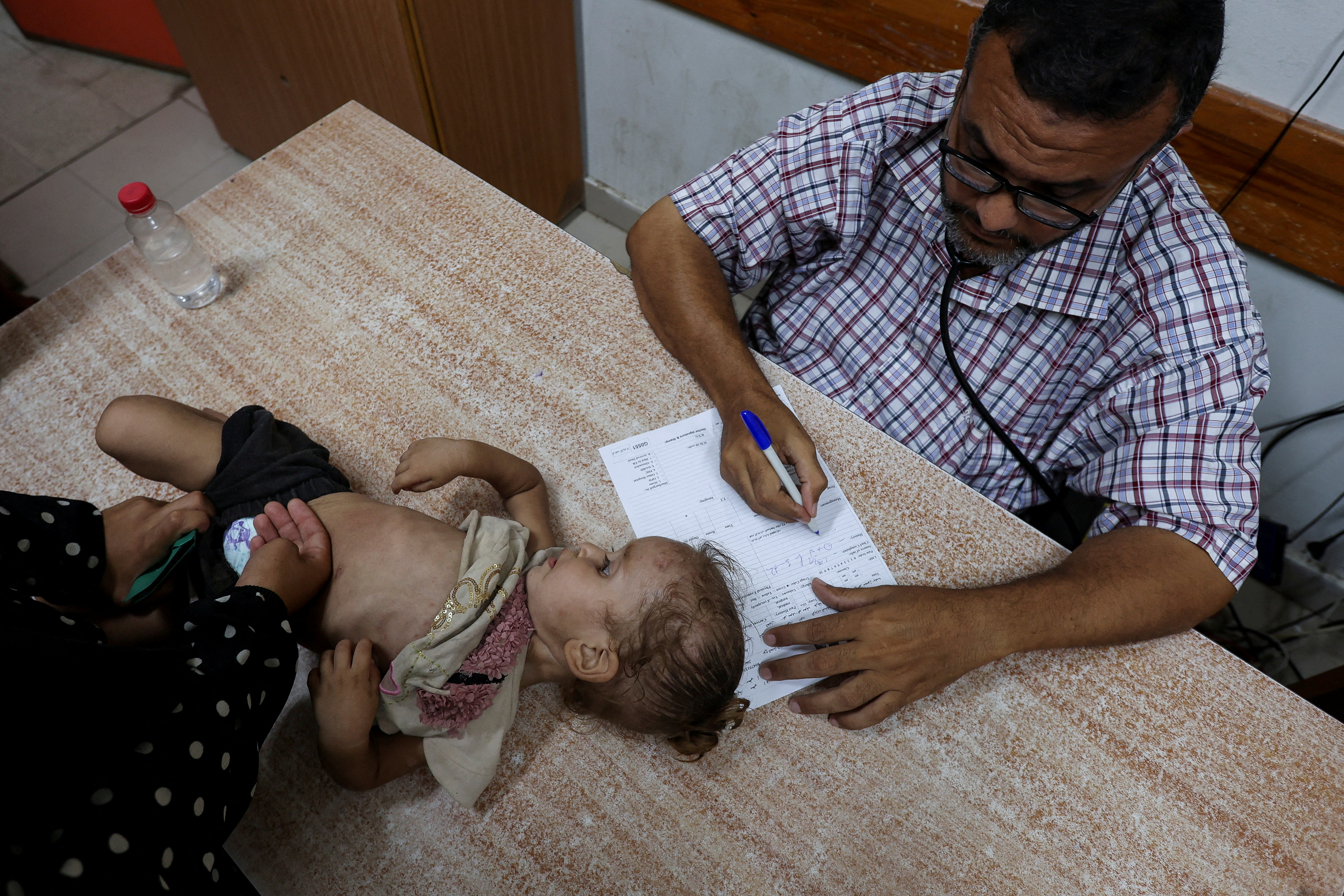 A Palestinian girl is examined by a doctor as the conflict between Israel and Hamas continues. /Ramadan Abed/Reuters