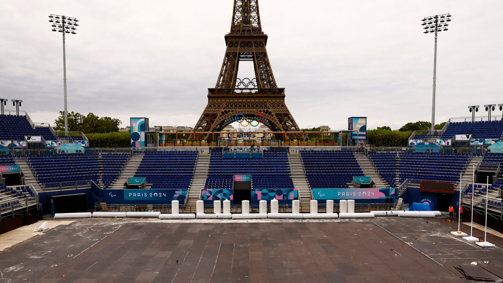 Workers converting the Eiffel Tower Stadium from the beach volleyball venue to a Paralympic blind football venue. /Abdul Saboor/Reuters
