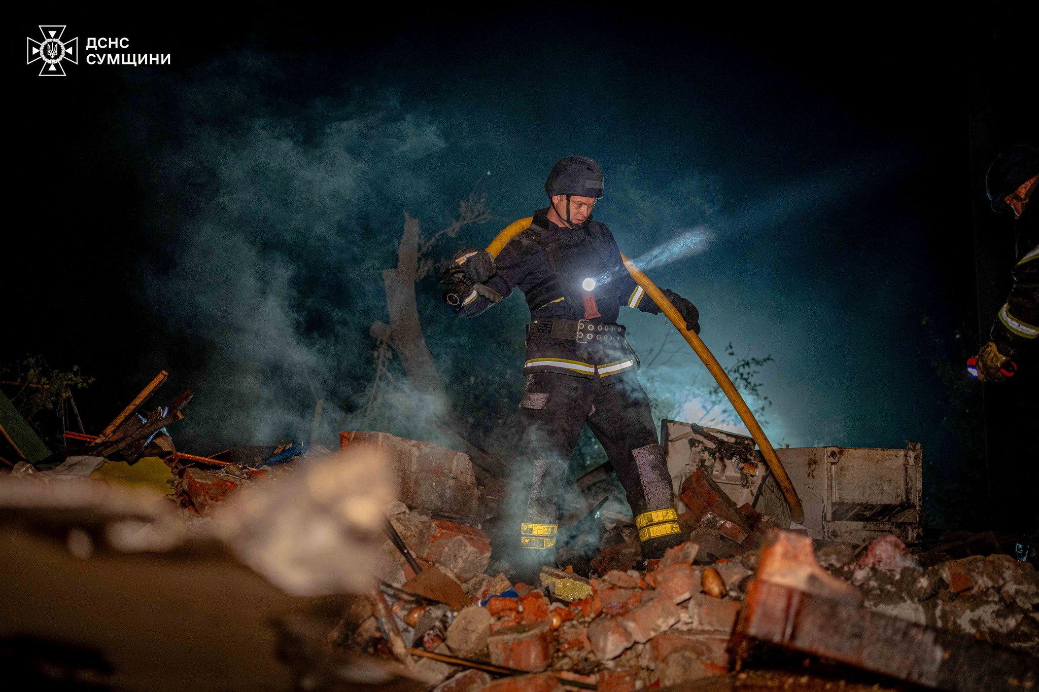 A firefighter works at a site of residential building damaged by a Russian air strike in Sumy. /State Emergency Service of Ukraine