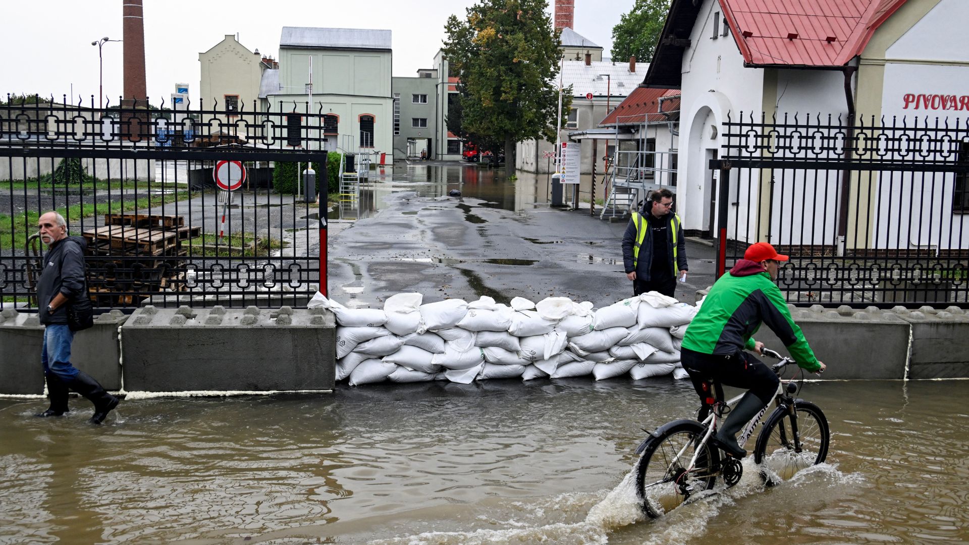 A person rides a bicycle through a flooded street, following heavy rainfalls in Litovel, Czech Republic. /Radovan Stoklasa/Reuters
