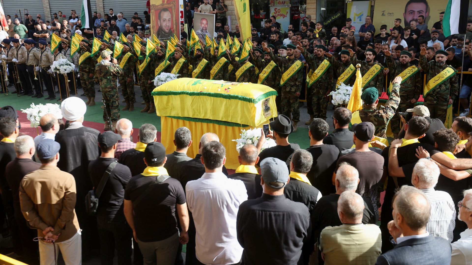 Hezbollah members salute next to the coffin of Hezbollah member Ali Mohamed Chalbi, after hand-held radios and pagers used by Hezbollah detonated across Lebanon, during his funeral in Kfar Melki. /Aziz Taher/Reuters