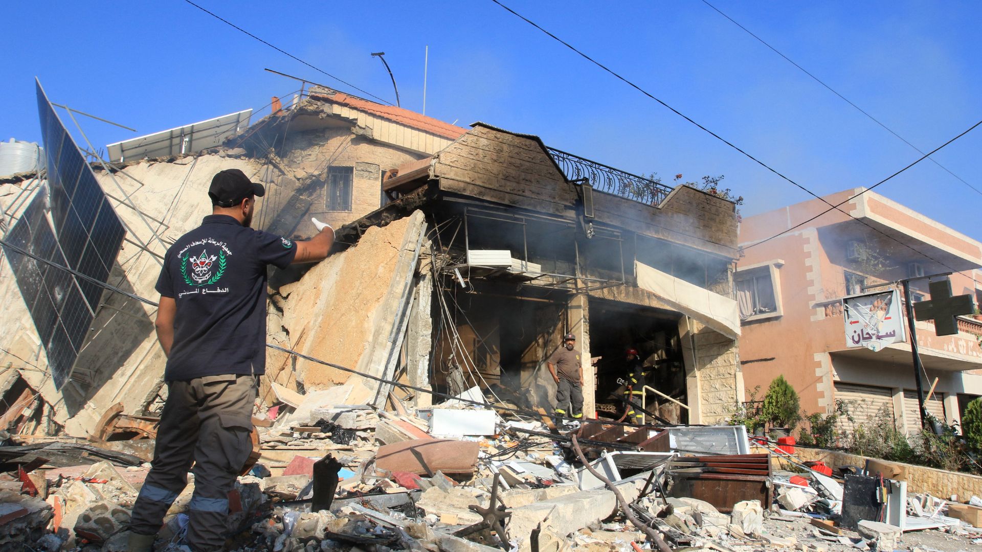 A rescuer inspects the debris at the site of an overnight Israeli strike on a pharmacy in the southern Lebanese village of Akbiyeh. /Mahmoud Zayyat/AFP