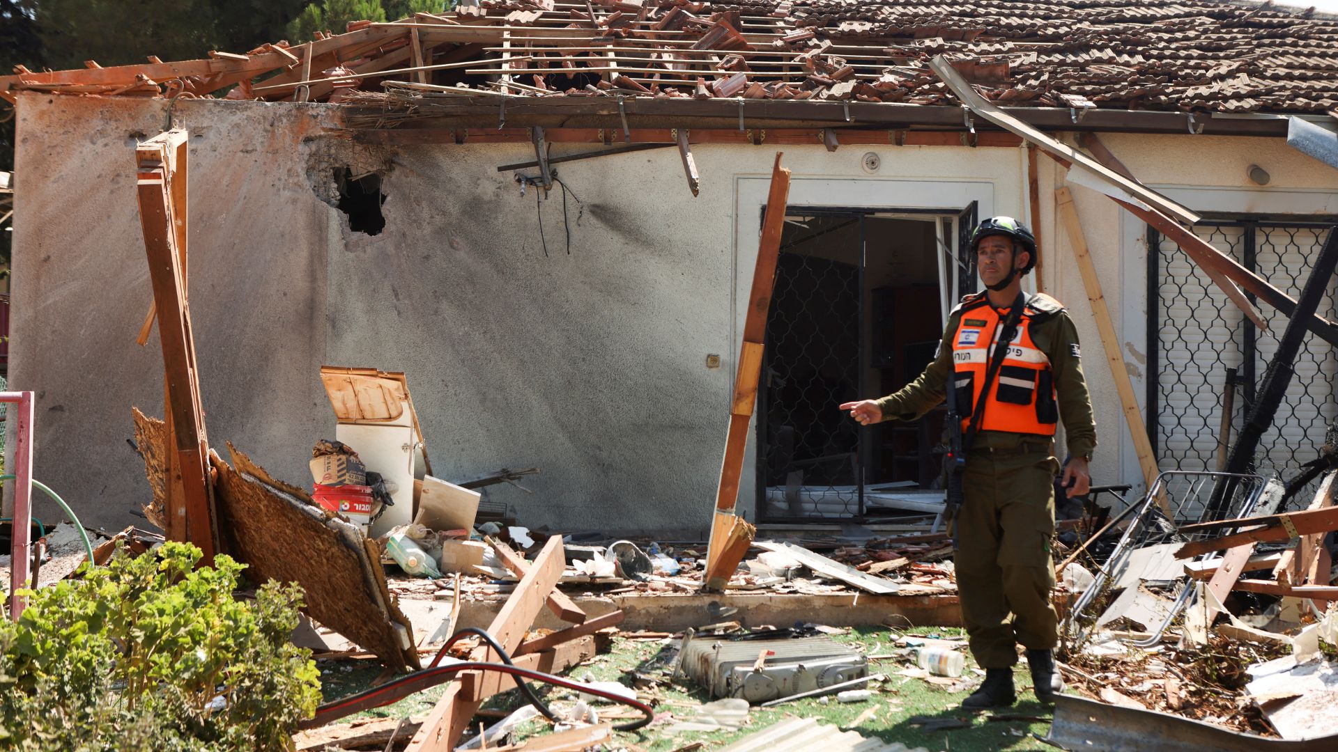 A member of the Israeli Army stands at the scene of a damaged home following a rocket attack from Lebanon in northern Israel. /Jim Urquhart/Reuters