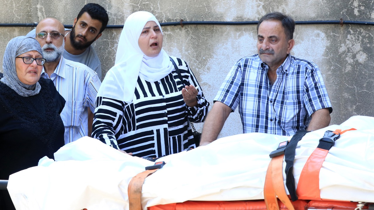 Lebanese mourn over the bodies of relatives in the southern city of Sidon. /Mahmoud Zayyat/AFP