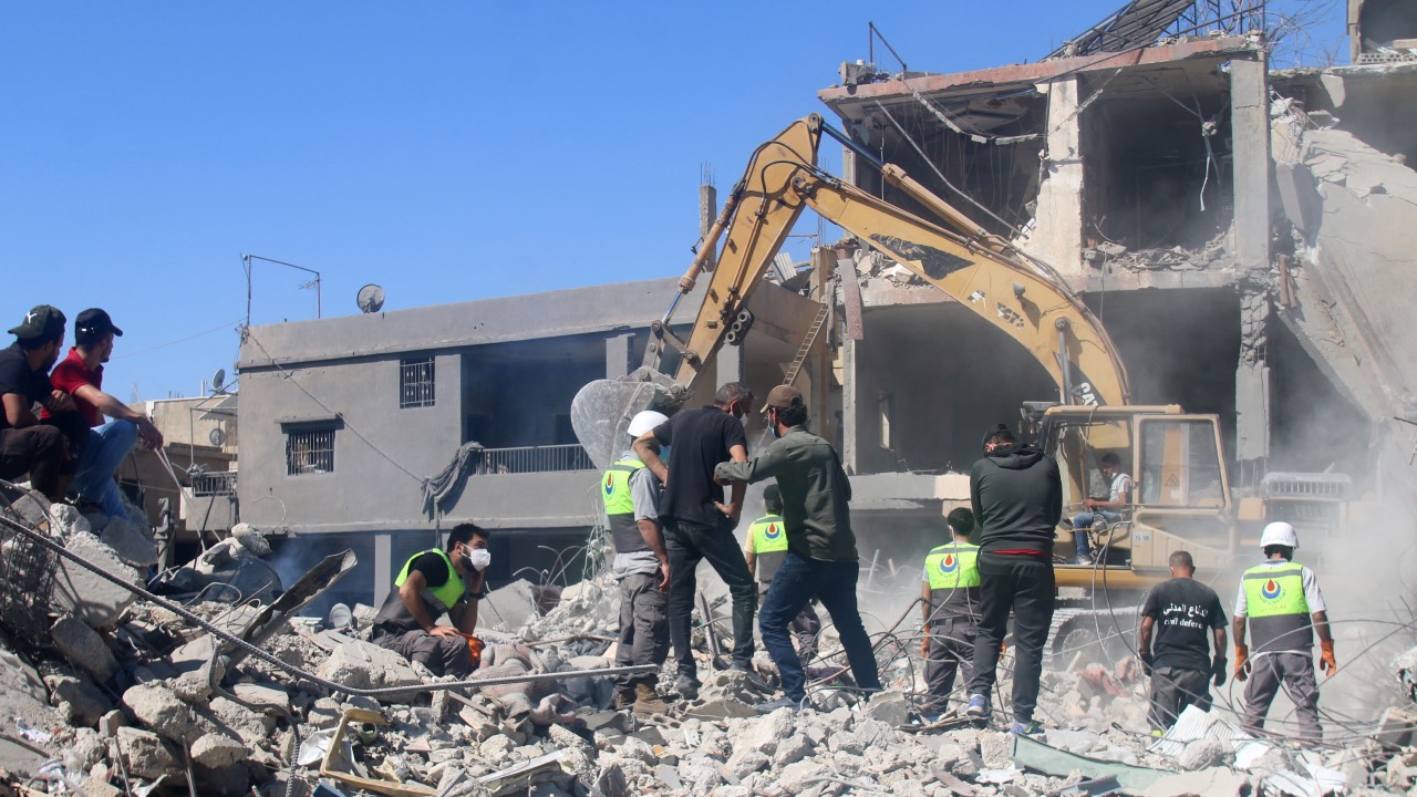 Civil defense workers dig through the rubble of a building at the site of an overnight Israeli airstrike that targeted a neighborhood in Lebanon's eastern city of Baalbek. /AFP