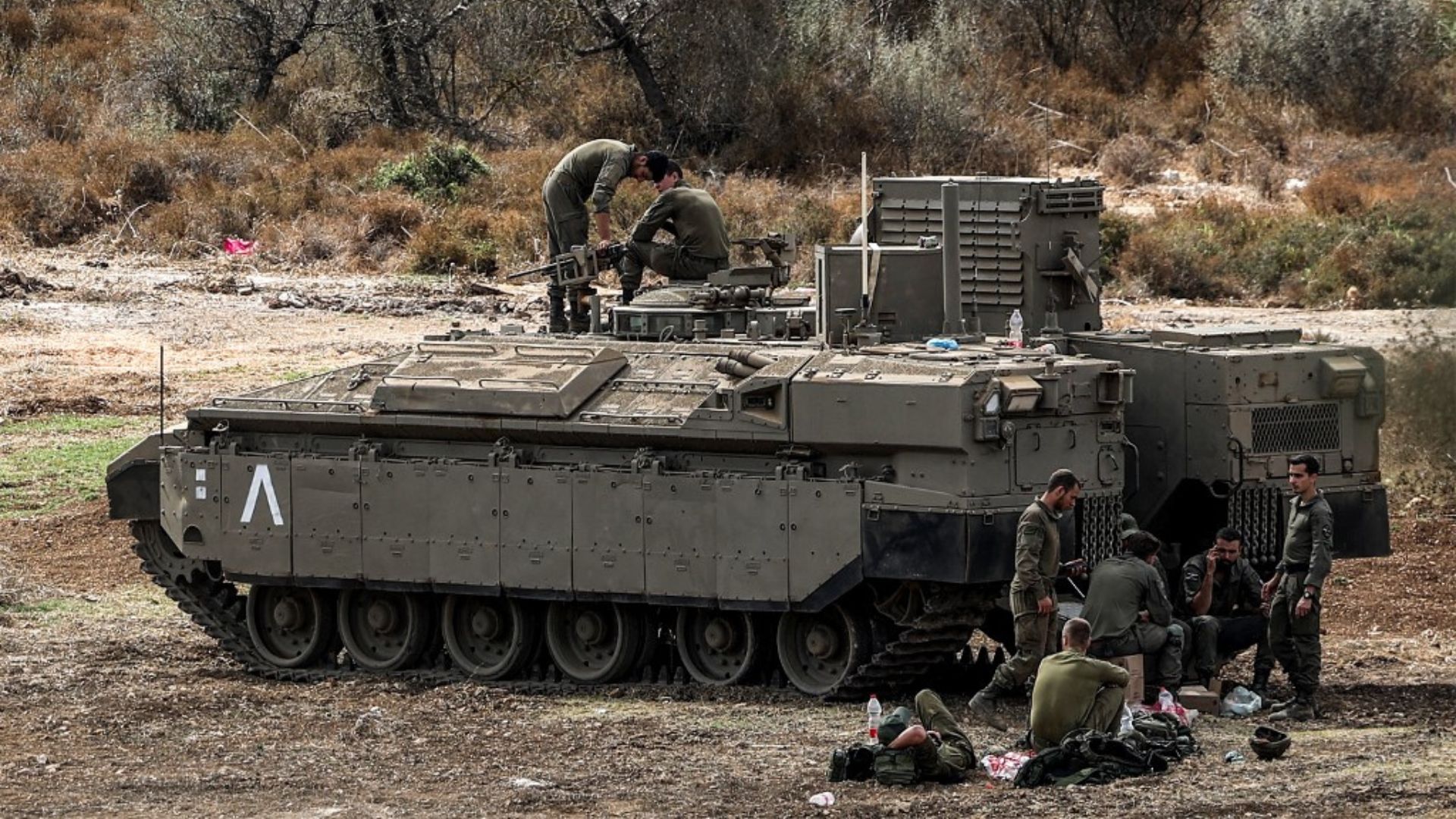 Israeli army soldiers with an infantry-fighting vehicle at the border with Lebanon in northern Israel on October 1. /Ahmad Gharabli/AFP
