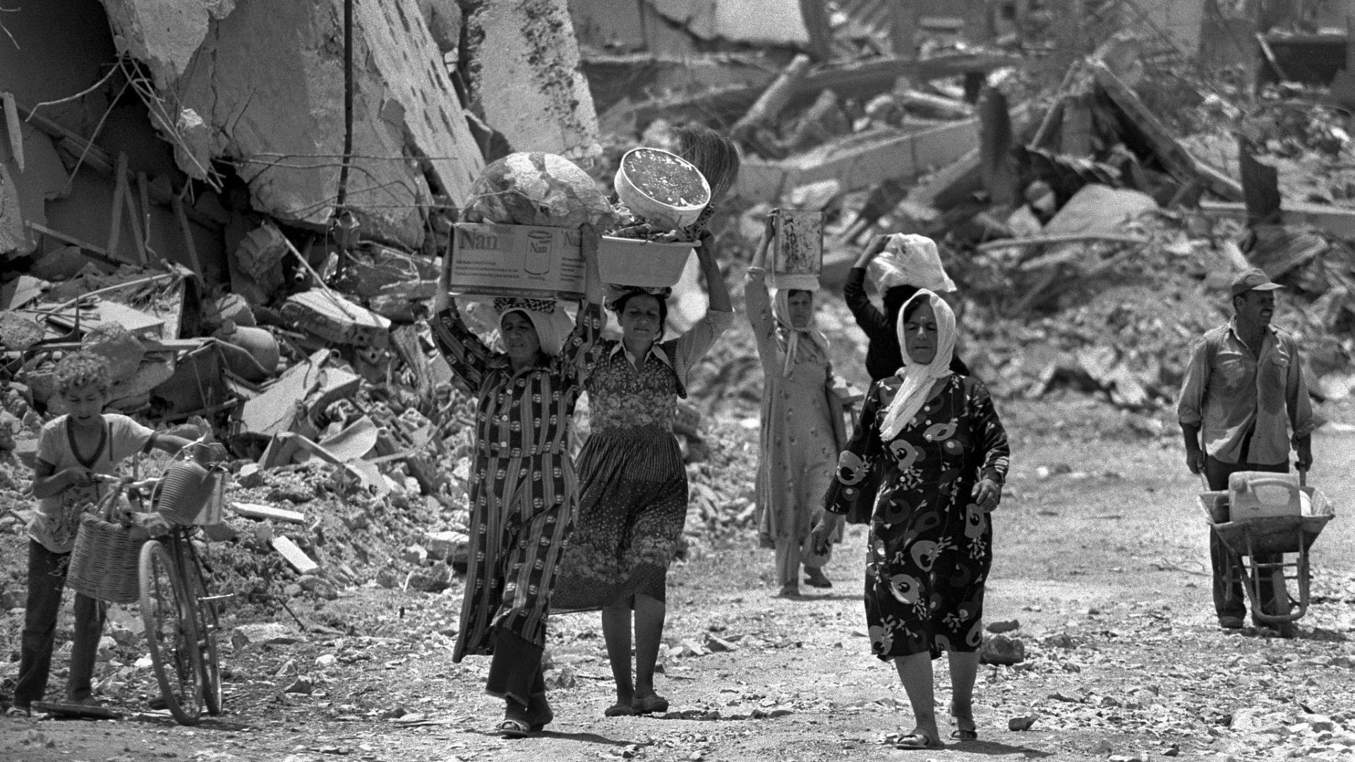 Women pass a destroyed militants' outpost in Ein el-Hilwe, Lebanon in 1982. /Ya'akov Sa'ar/Israeli GPO/Getty Images via CFP