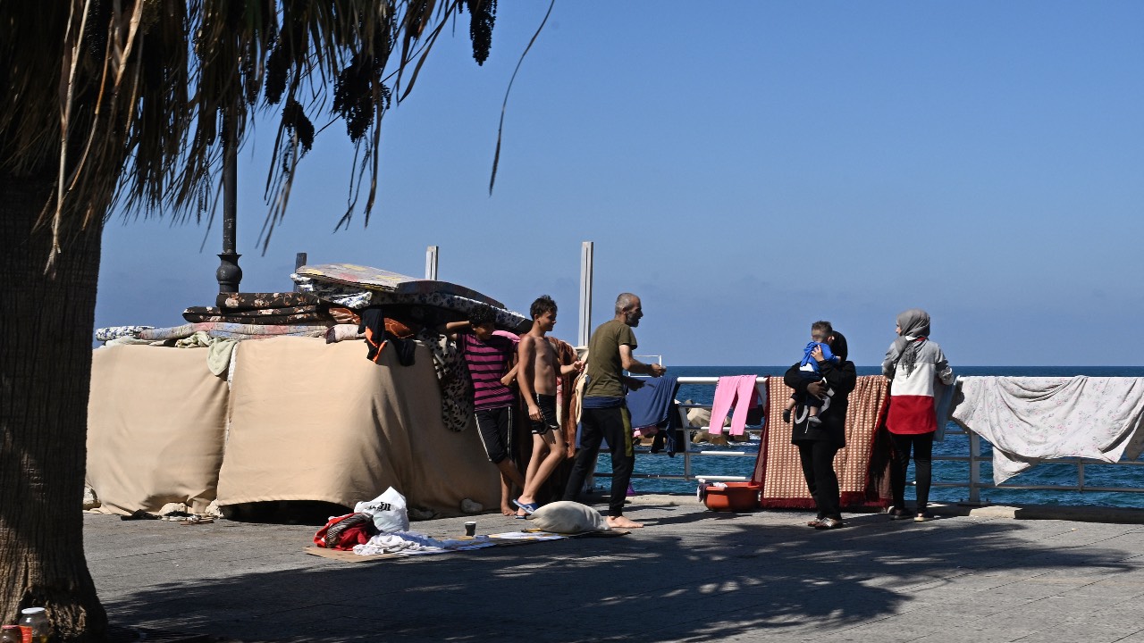 Displaced people gather along Beirut's seaside corniche promenade. /Joseph Eid/AFP