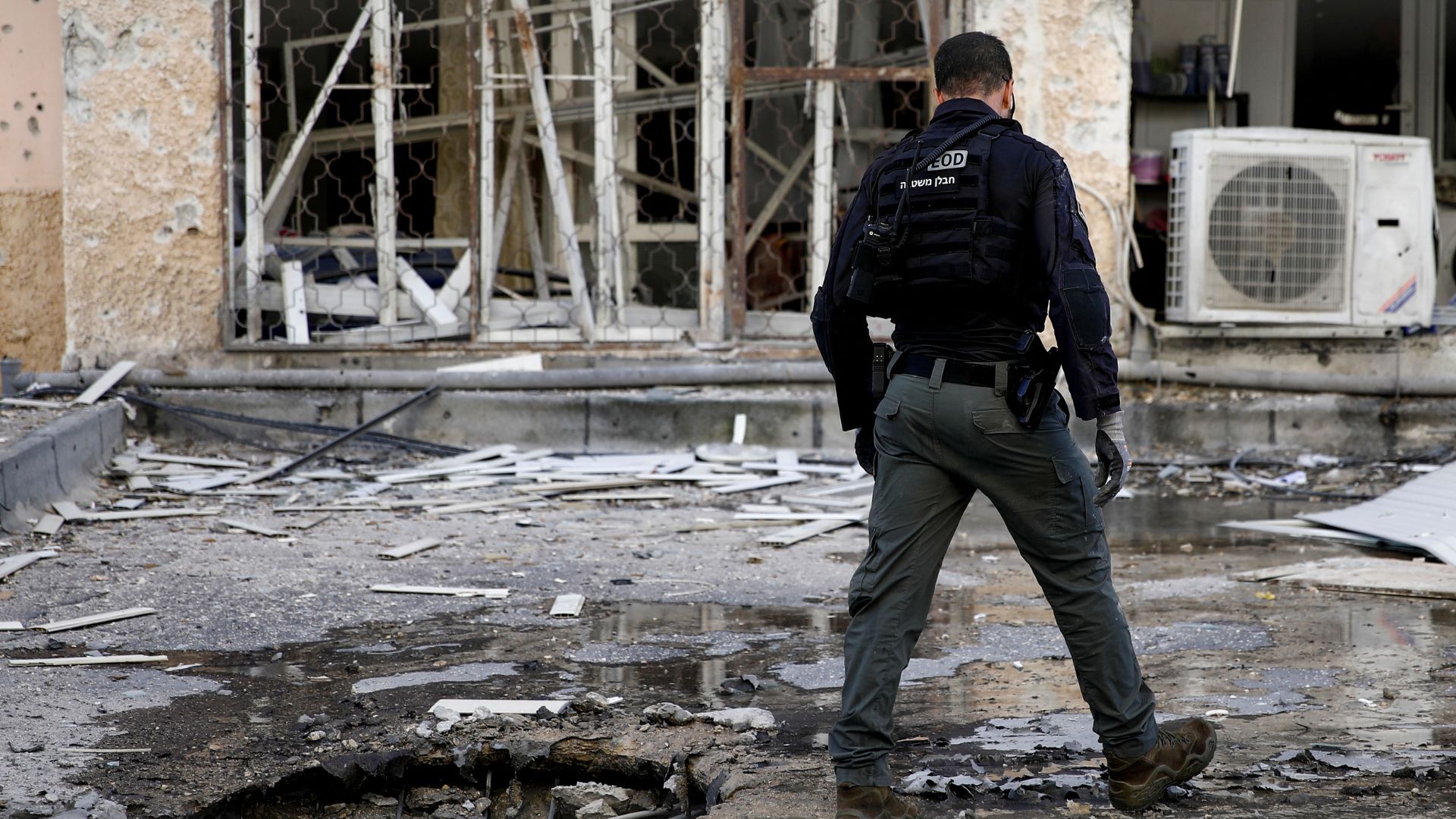 An Israeli emergency responder stands at the scene where a rocket, fired from Lebanon, damaged a residential apartment building in Kiryat Yam, northern Israel. /Shir Torem/Reuters