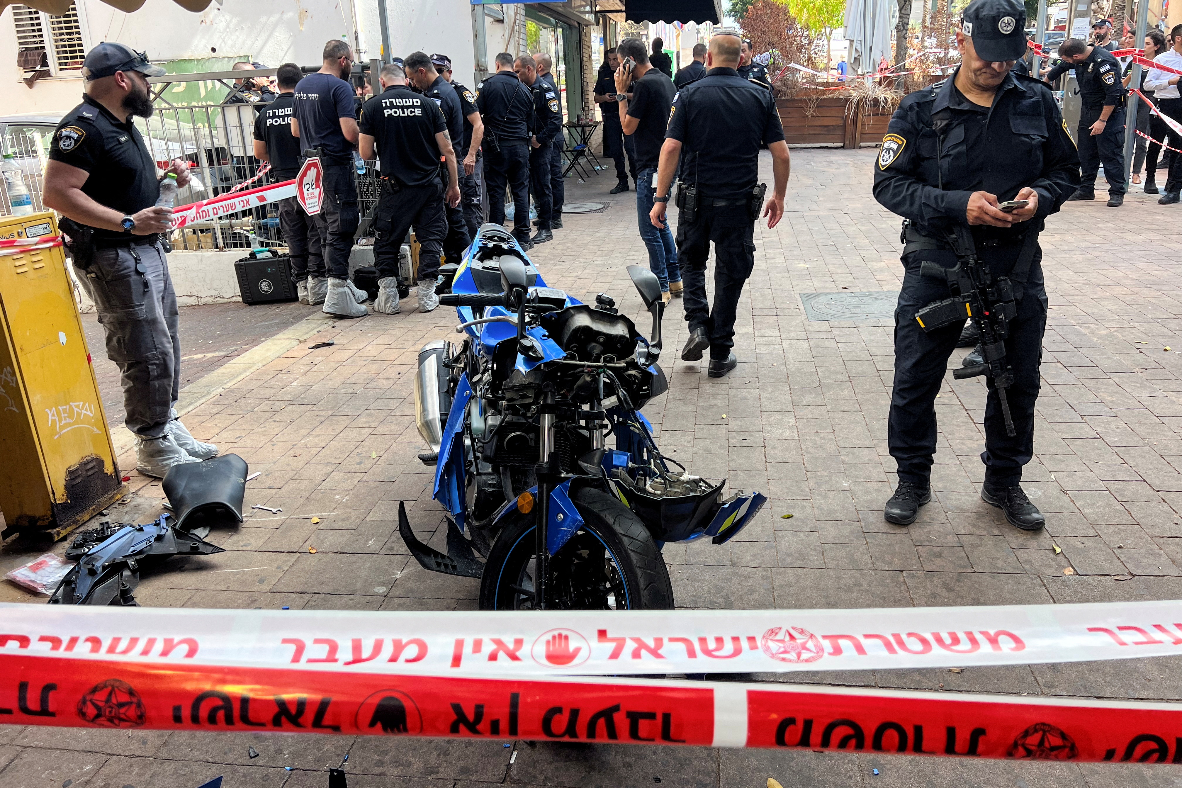 Israeli police stand around the motorbike of the attacker following a stabbing attack in Hadera, Israel. /Miro Maman/Reuters