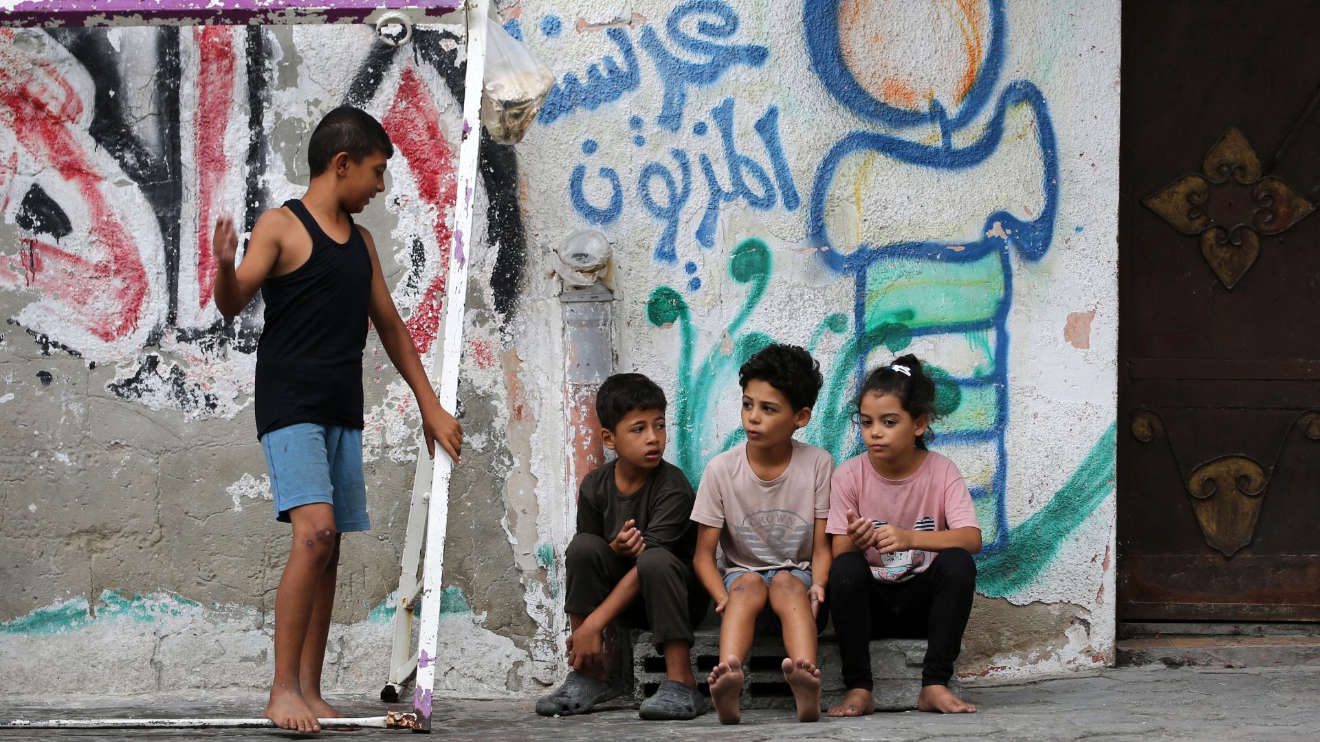 Children outside a house in the Bureij camp for Palestinian refugees in the central Gaza Strip. /Eyad Baba/AFP