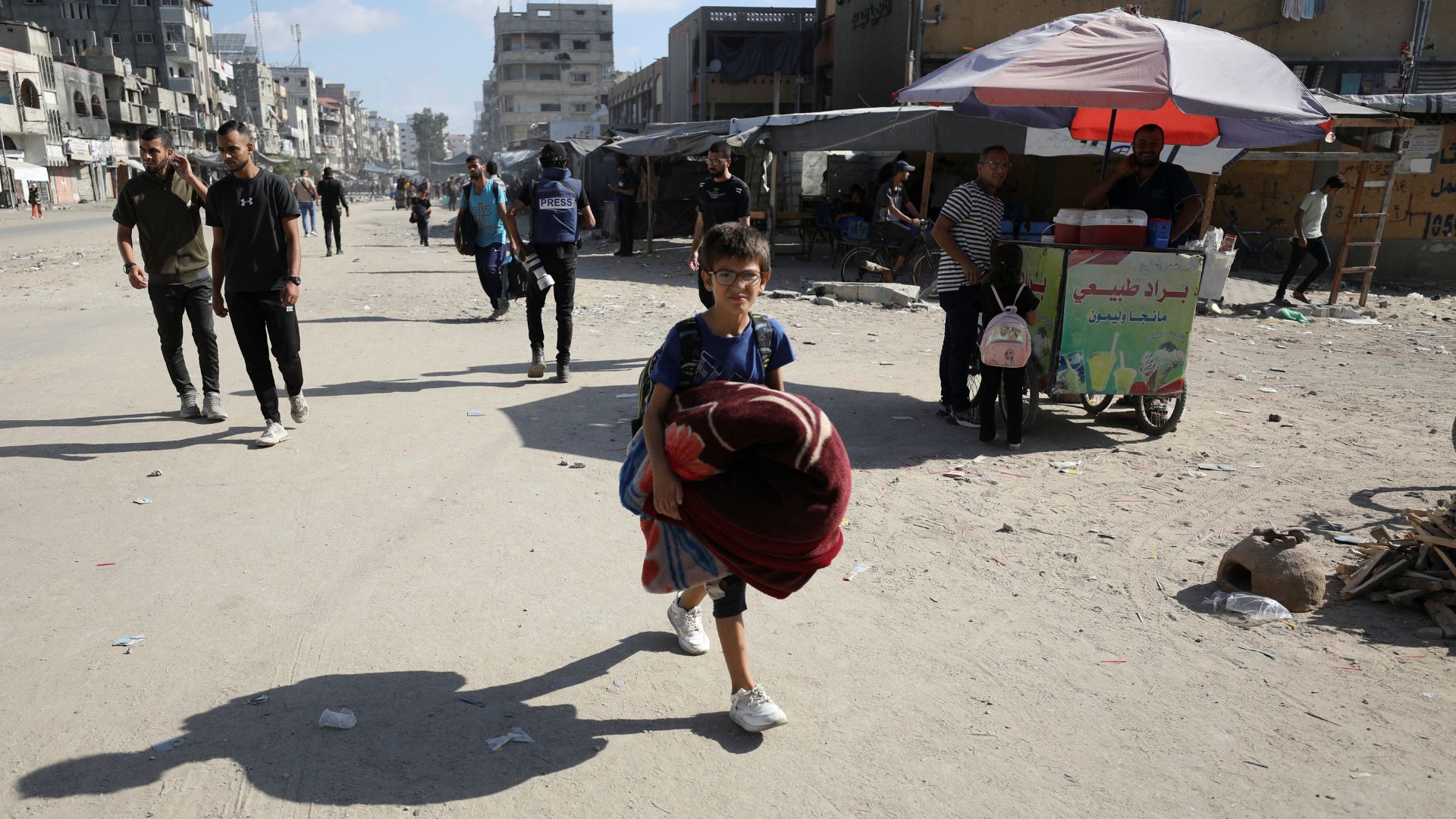 A child carries belongings as displaced Palestinians make their way to flee areas in the northern Gaza Strip, following an Israeli evacuation order. /Dawoud Abu Alkas/Reuters