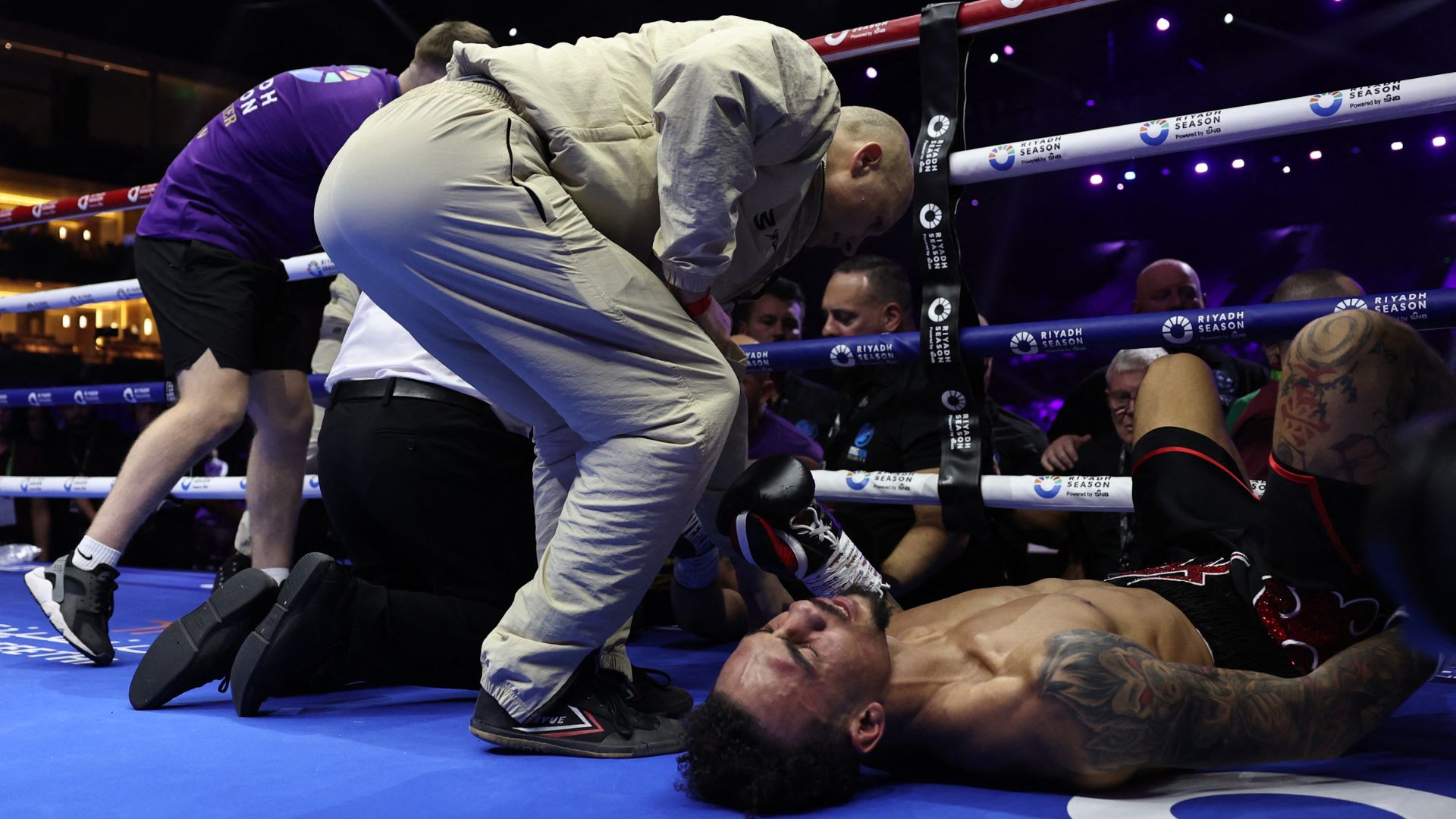 Whittaker lies prone on the canvas following the bizarre accident in Riyadh as officials come to the boxers' aid. /Hamad I Mohammed/Reuters